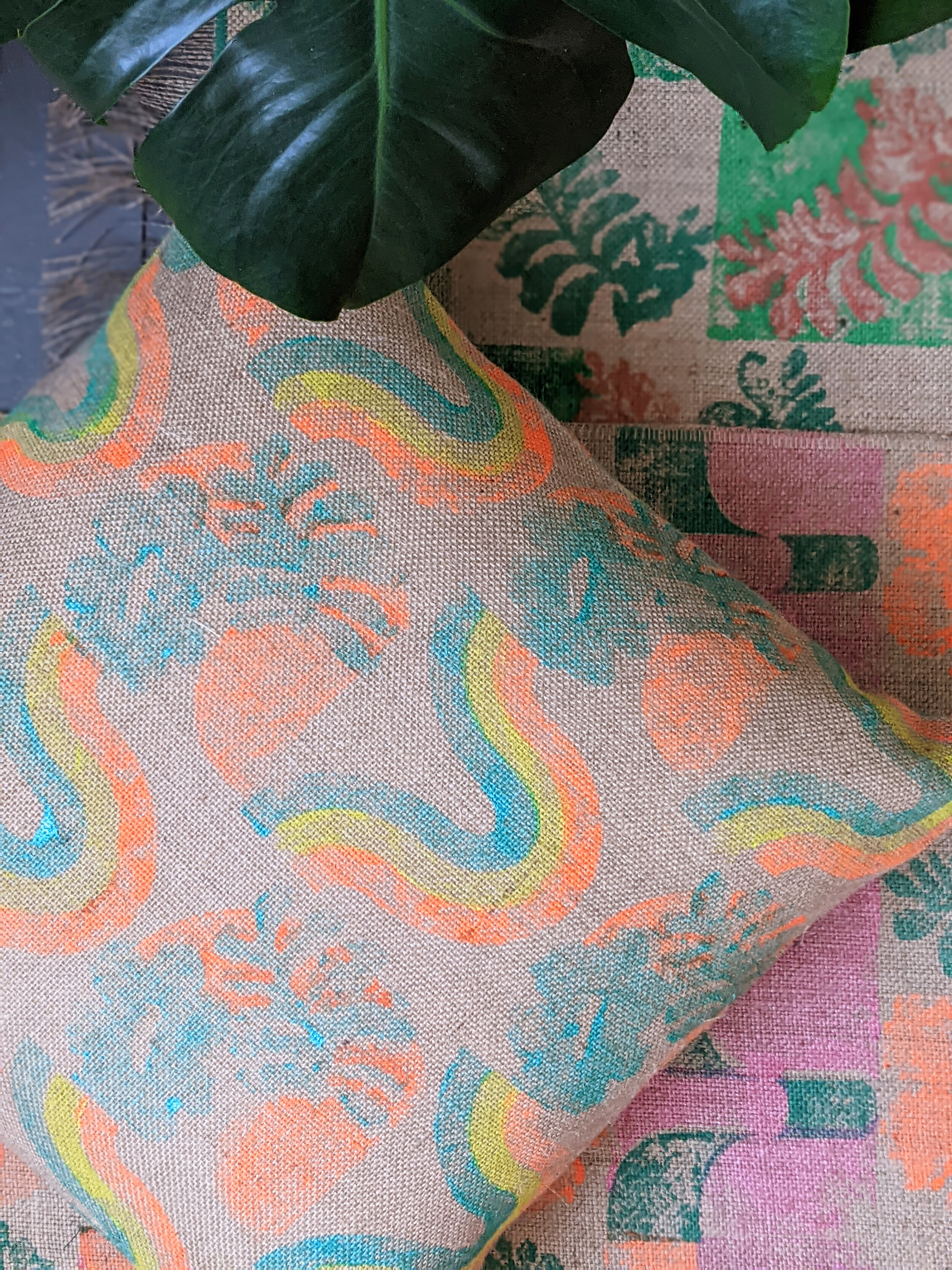 1970s retro inspired print on large square cushion with leaf and colourful rugs