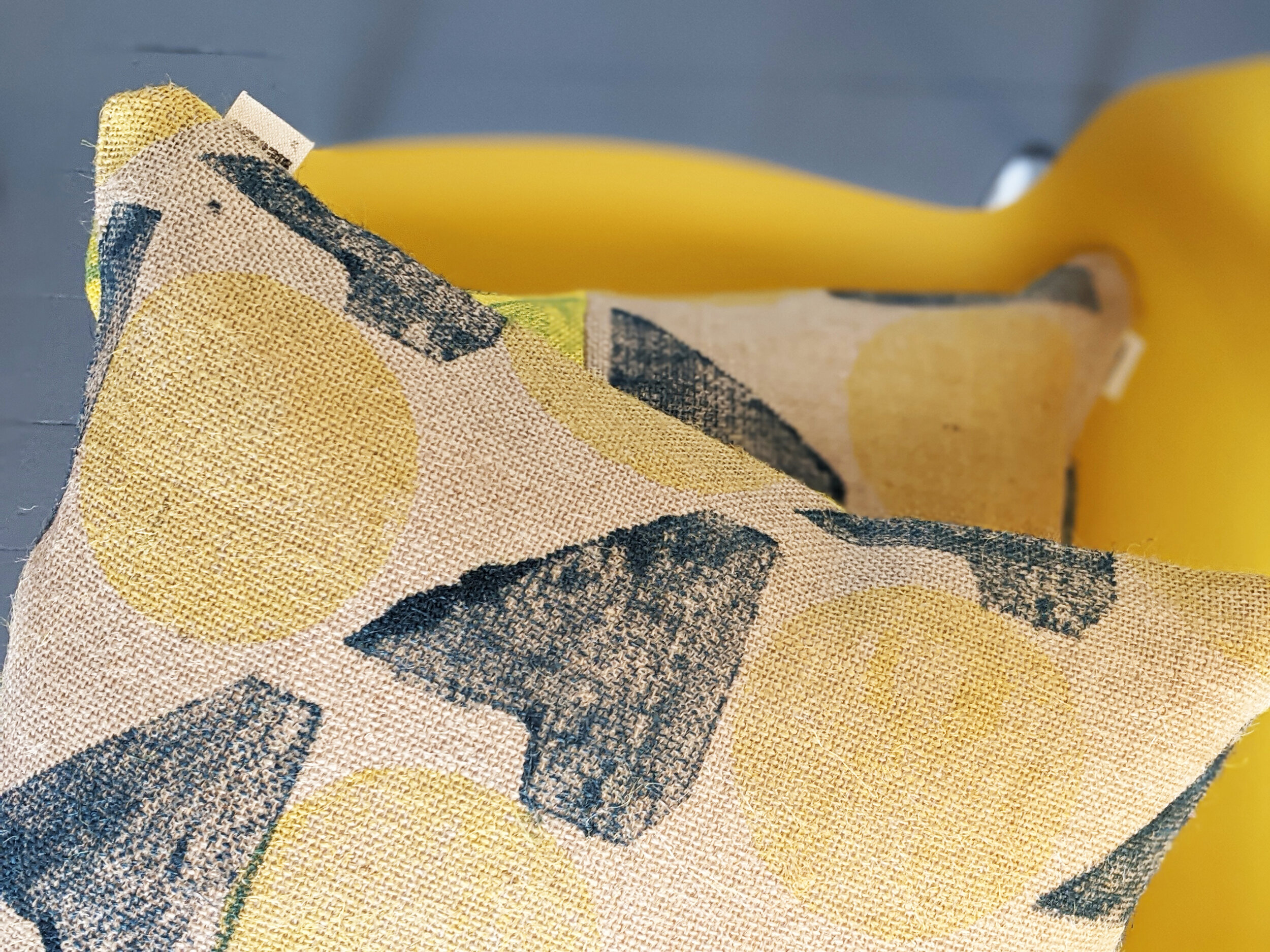 geometric print with yellow circle pattern on cushion laid on yellow chair
