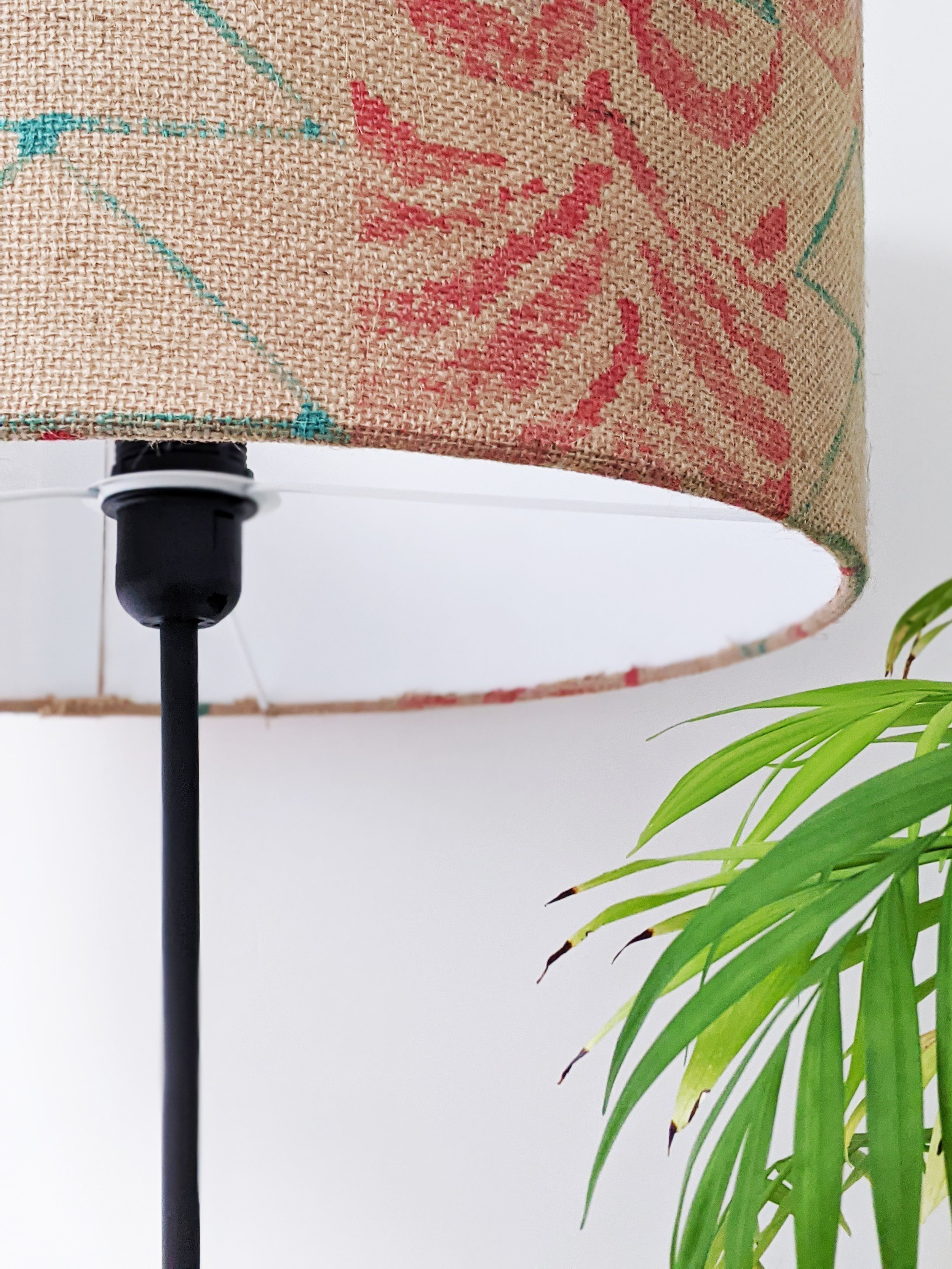 close-up on standing lamp with palm leaf print on natural jute