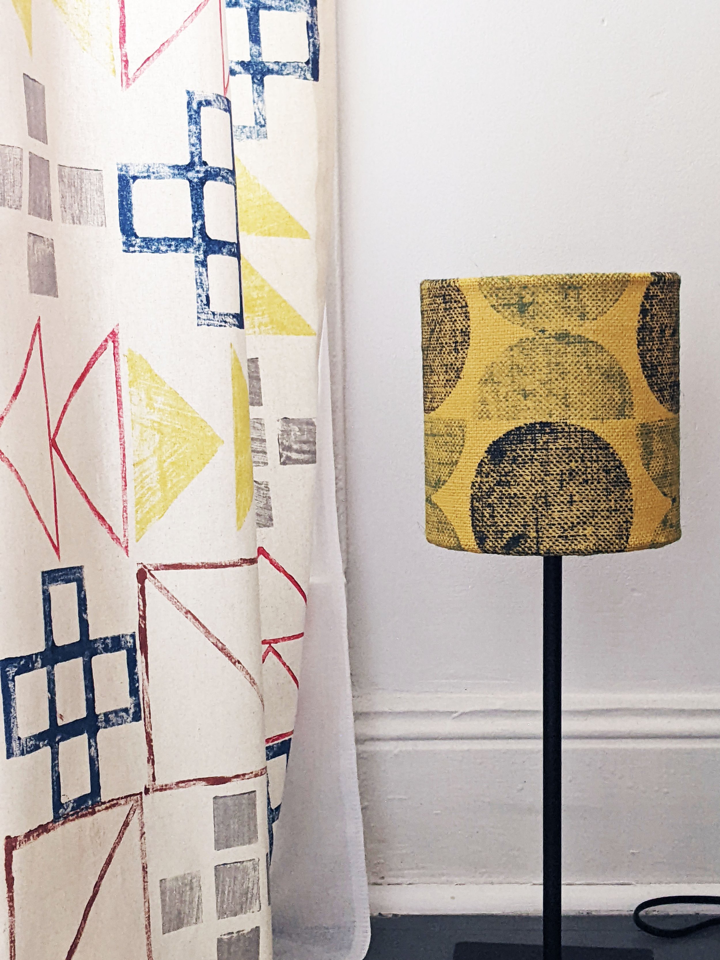 yellow small lamp on floor with hand block printed geometric design and curtains