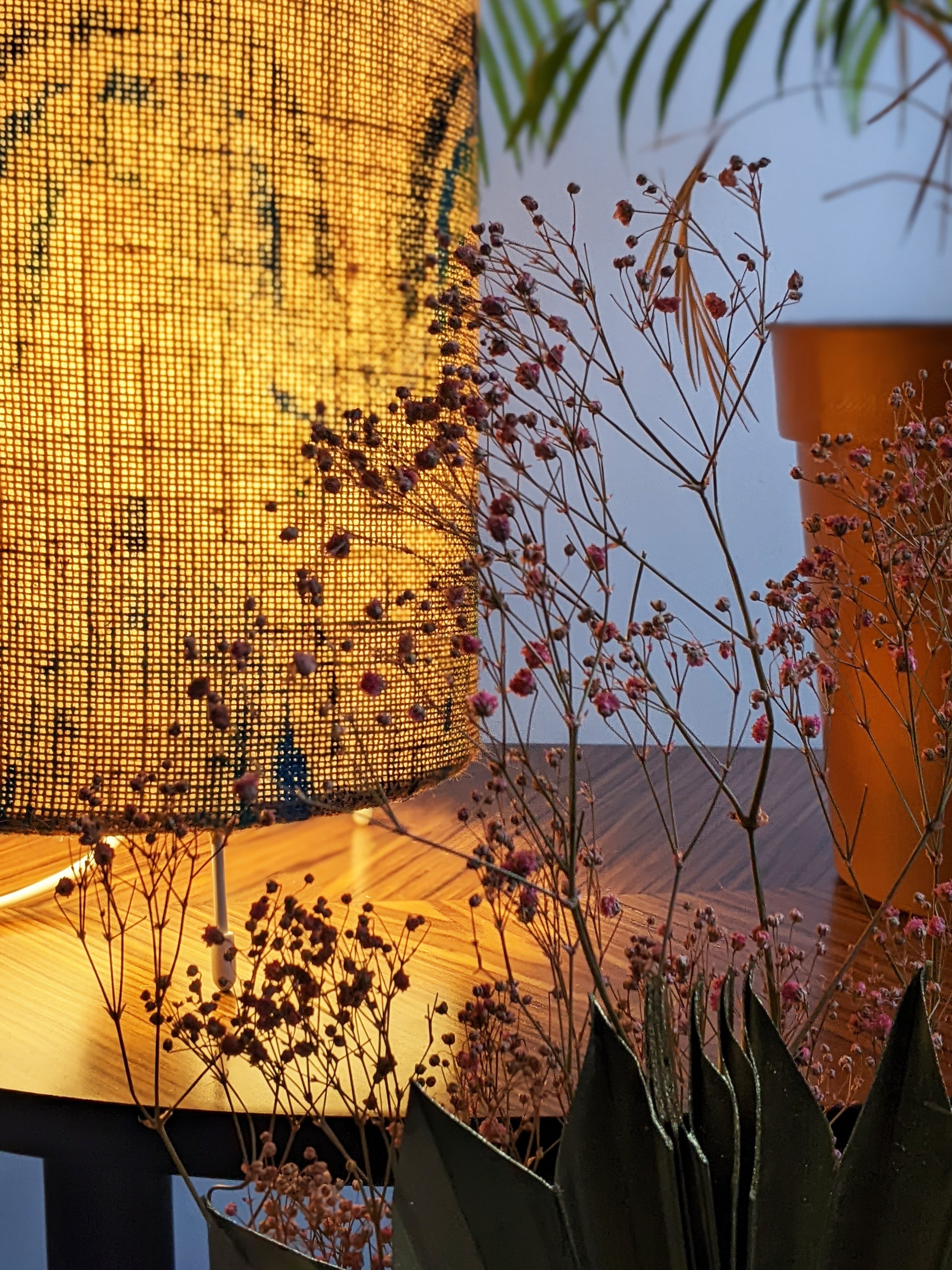 close-up detail of illuminated jute floorlamp with flowers and palm print