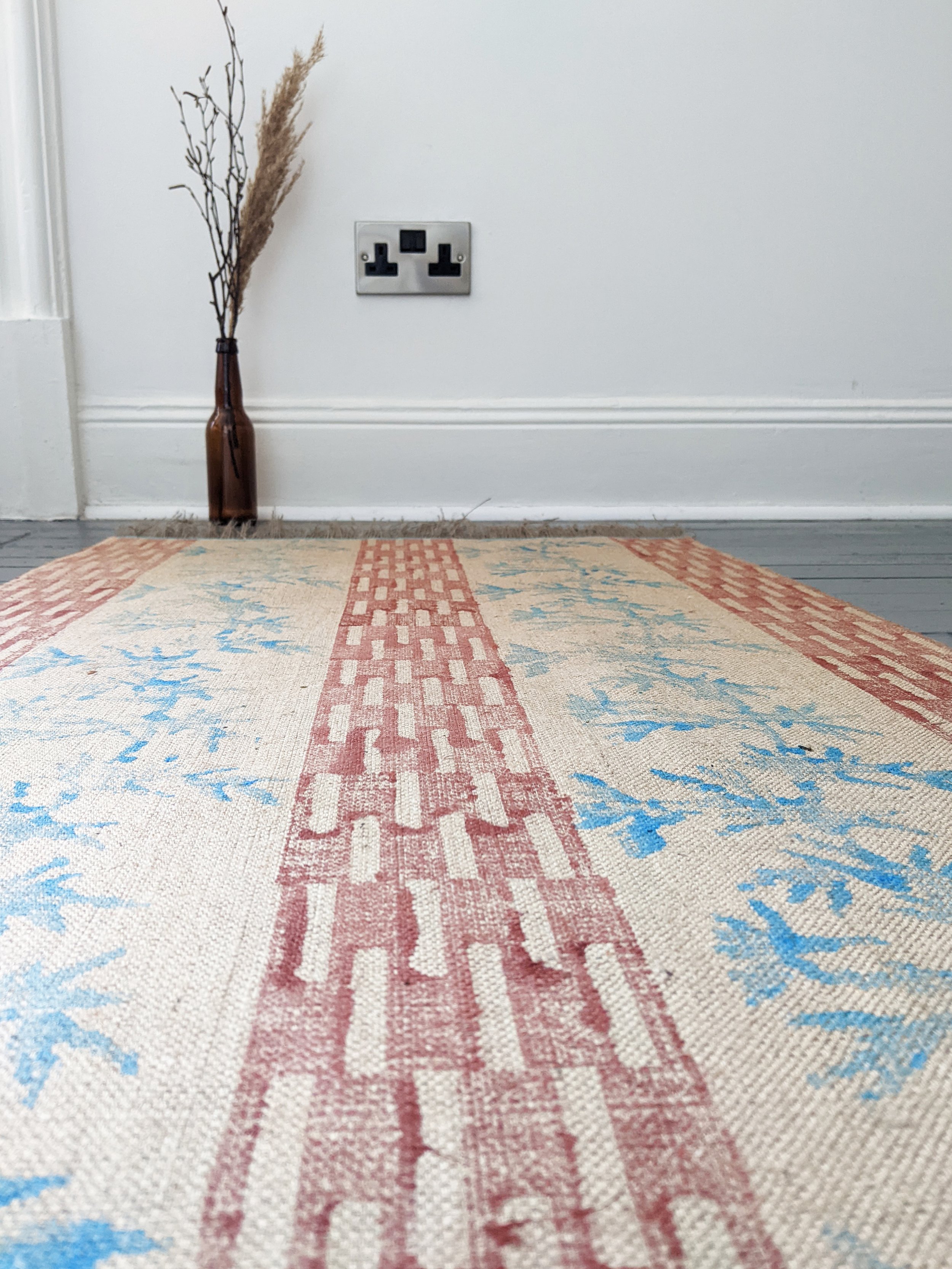 close-up detail of boho rug on floor with hand block printed pattern