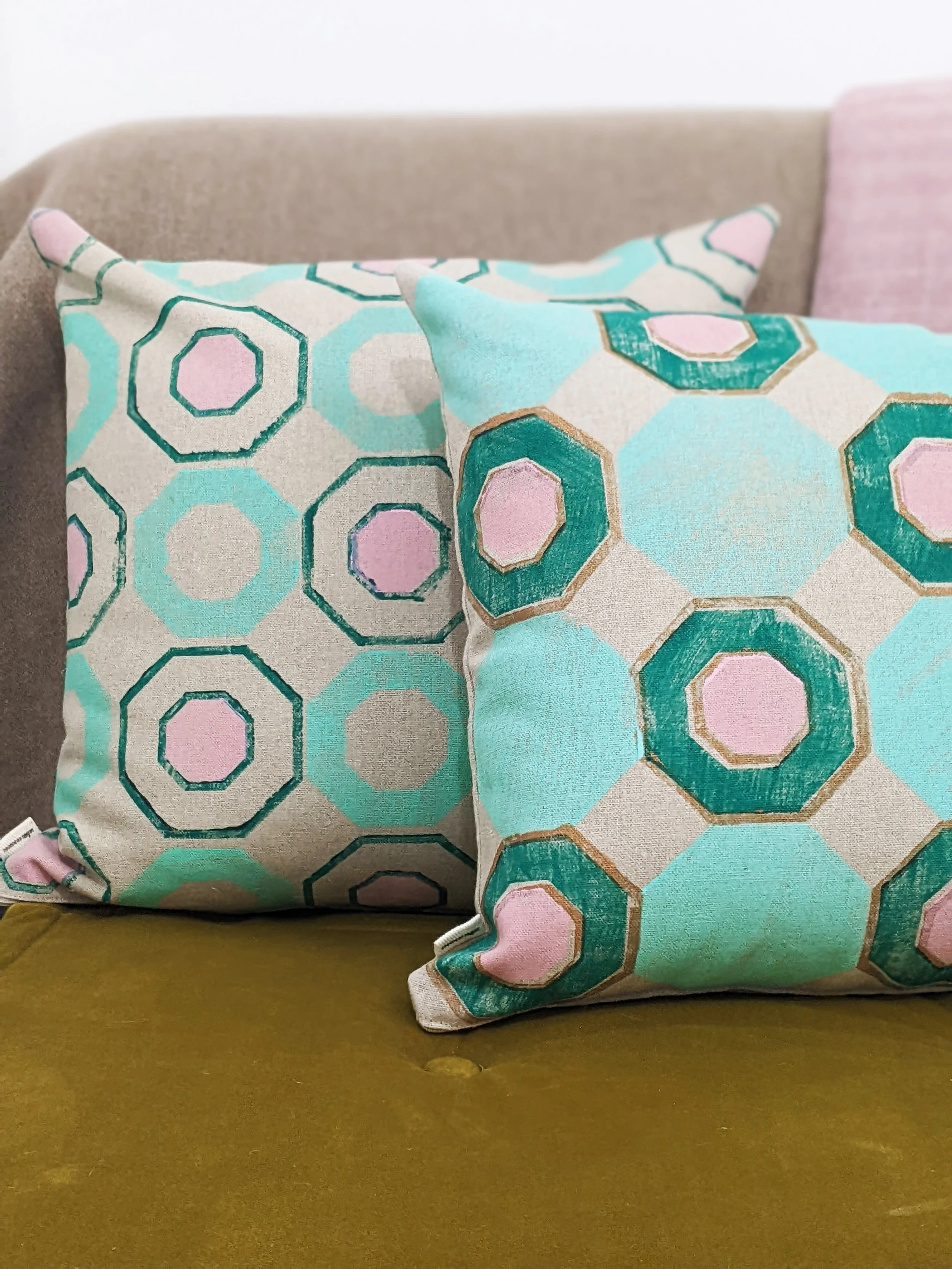 home interior scene with hand printed cushions on seat in mint green geometric print