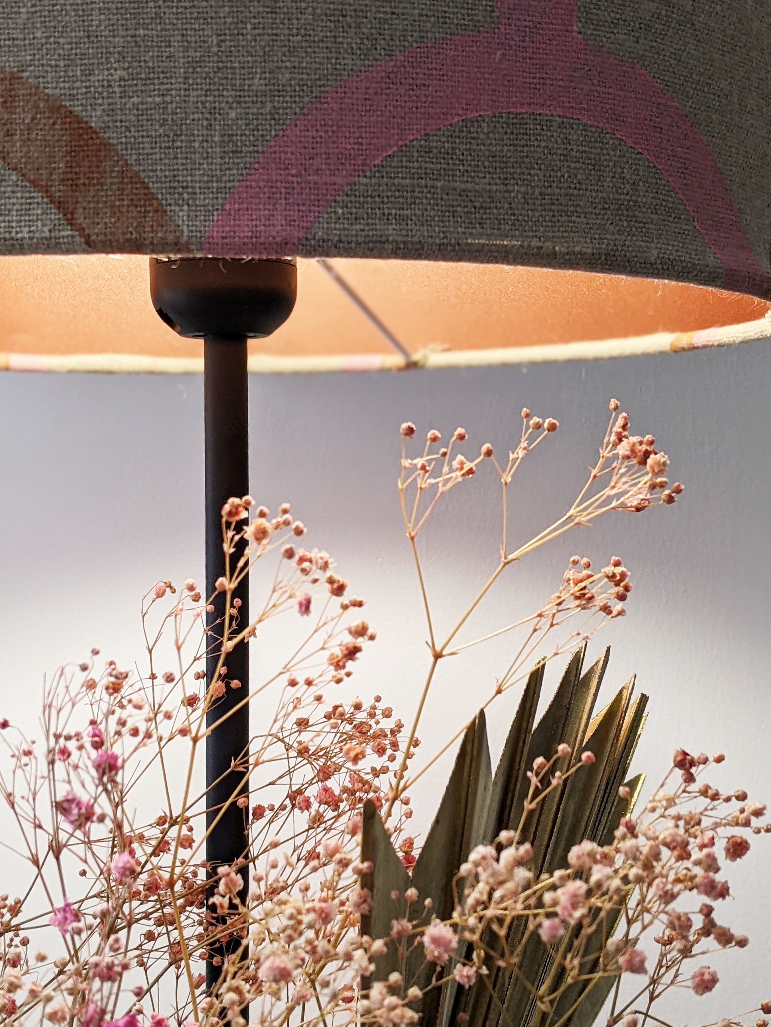 bronze lampshade reflecting light with flower arrengement