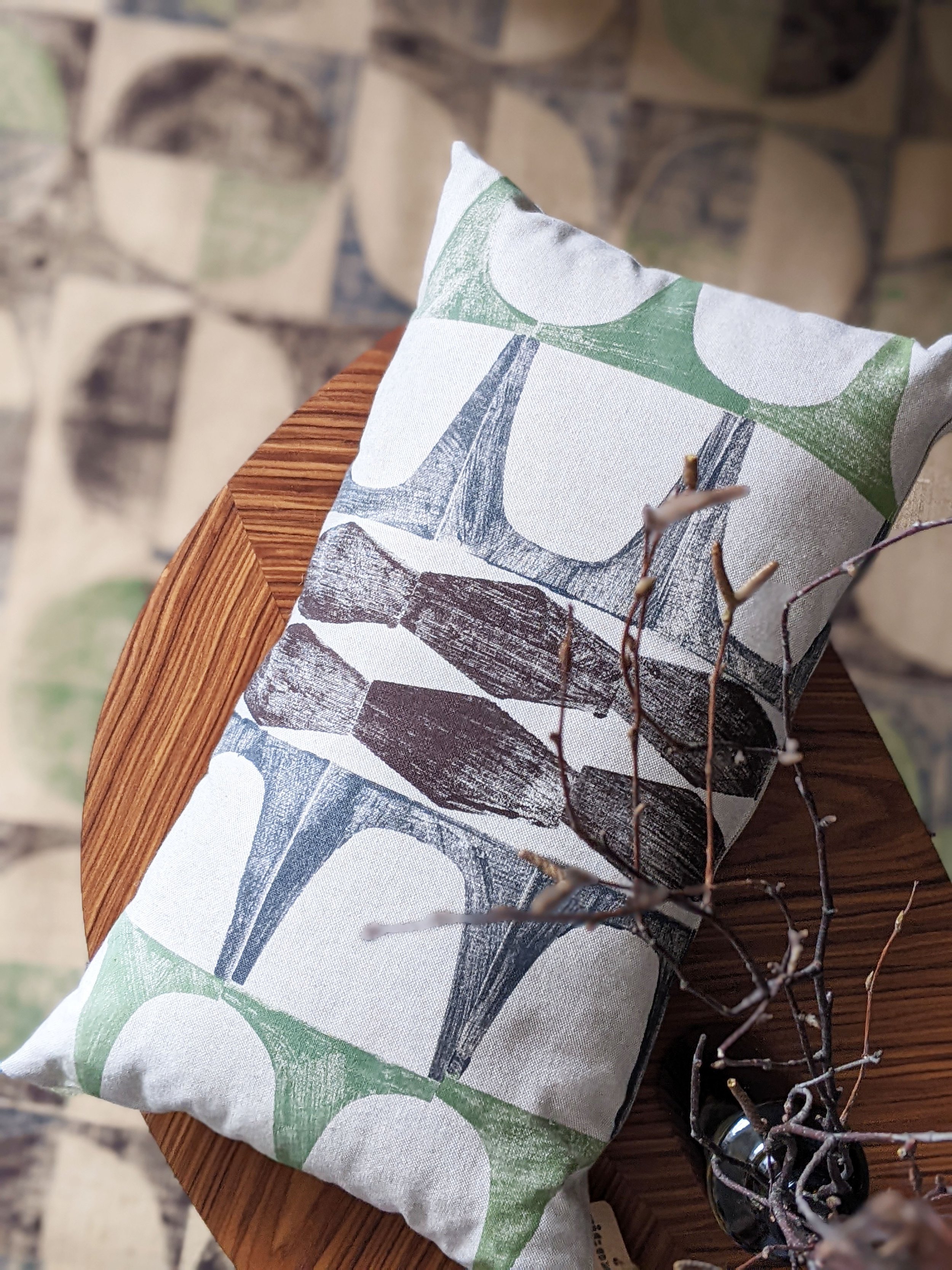 rectangular cushion on table with abstract geometric print in green and brown pattern