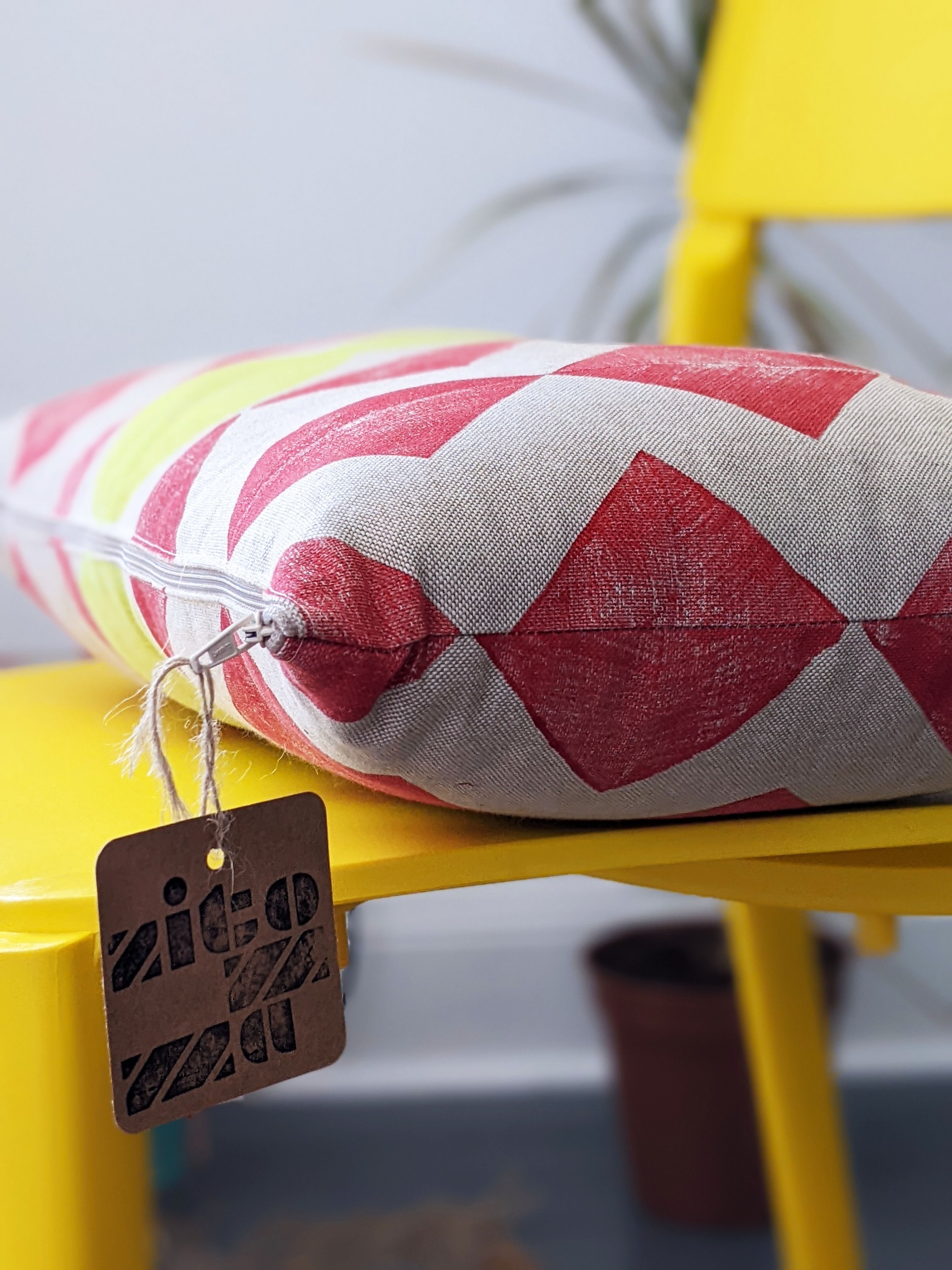 close-up detail of red chevron pattern on cushion on yellow chair