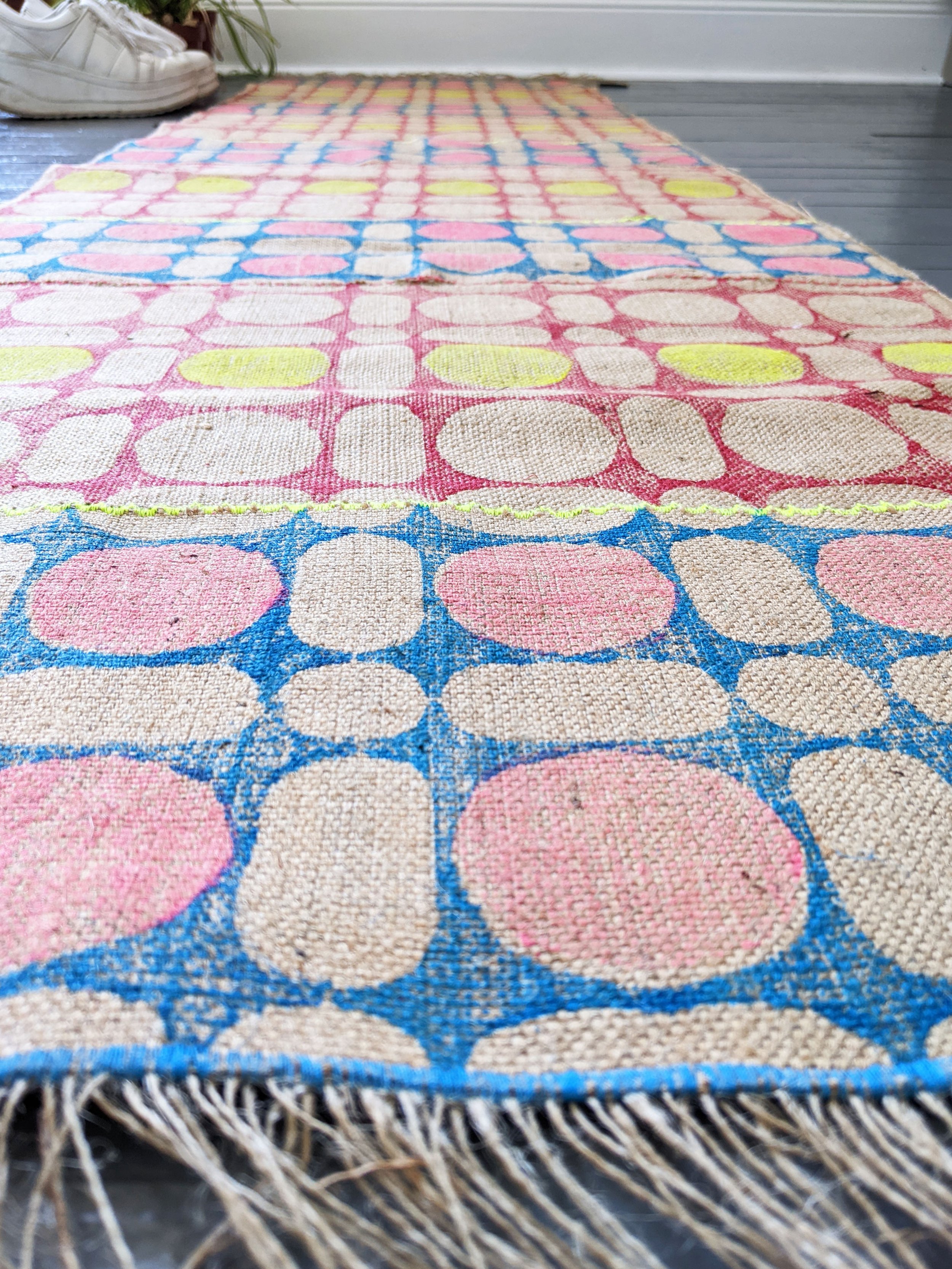 hand stitched, hand printed geometric rug on floor in close-up