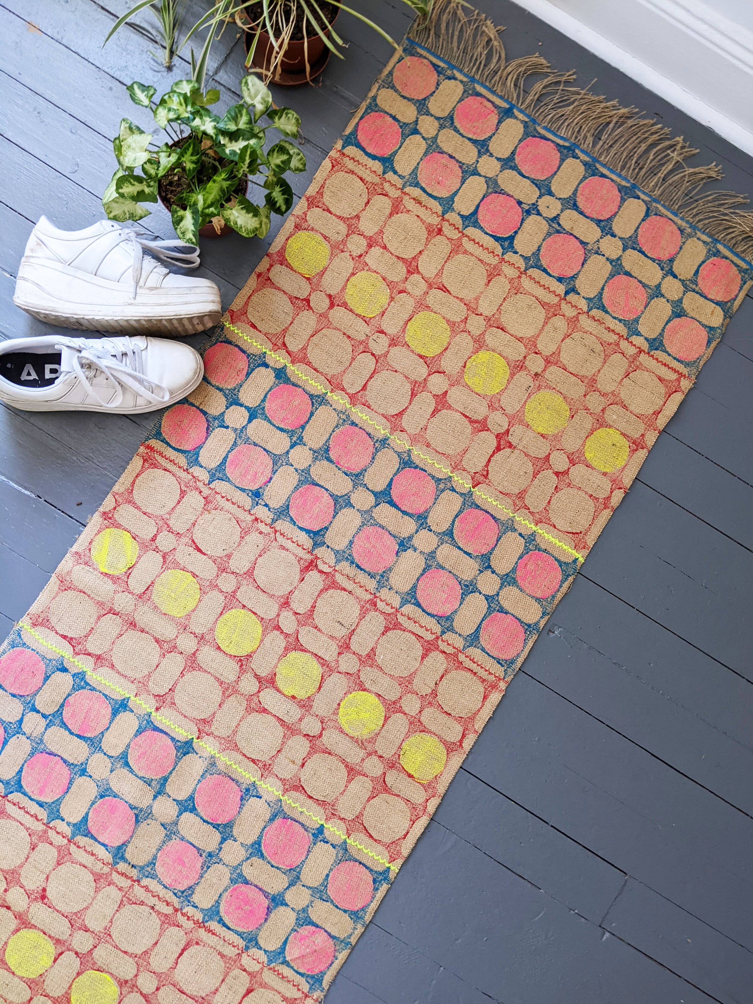 runner rug in modern colourful geometric pattern on floor with shoes and houseplant