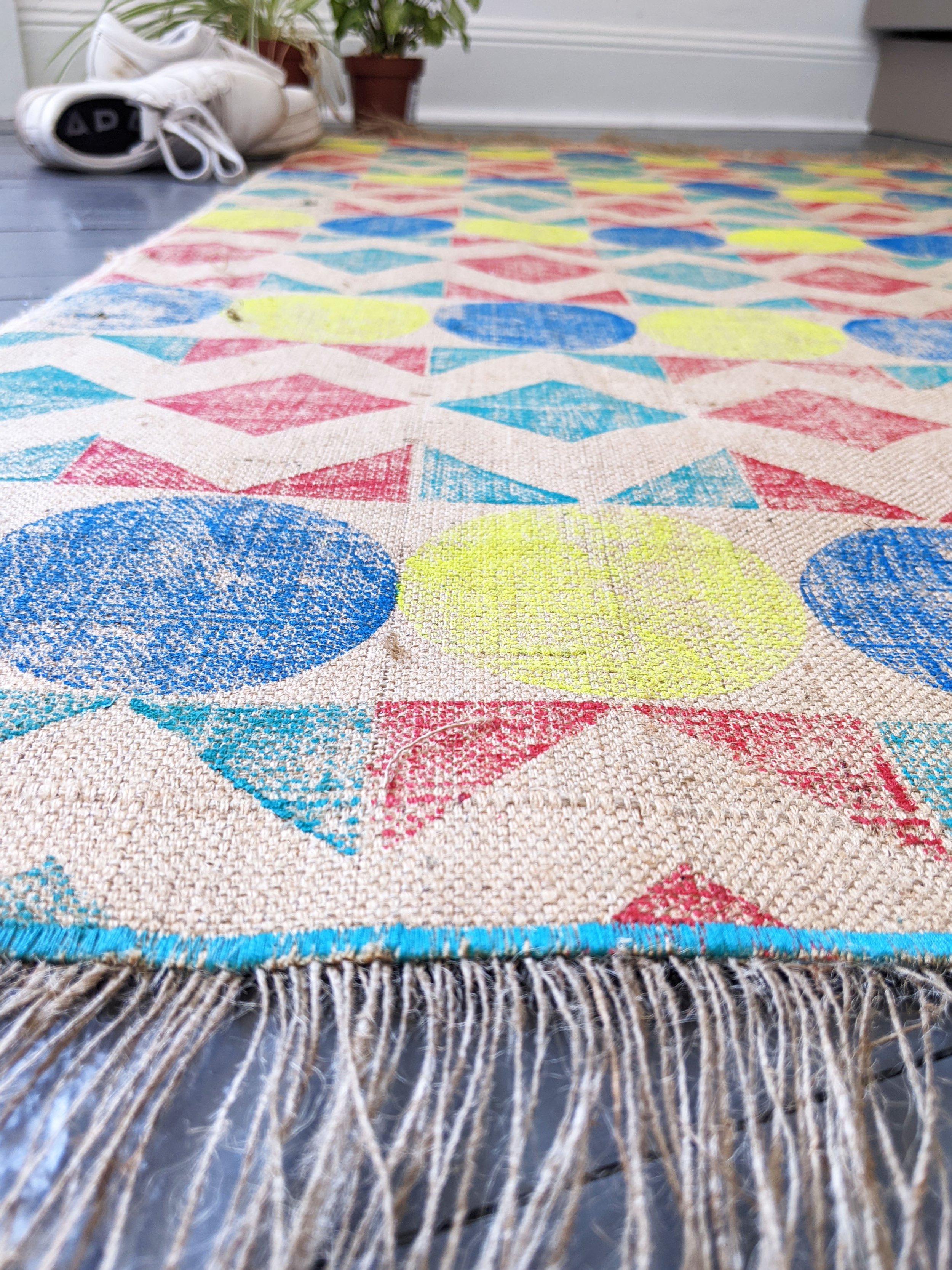 close-up details of printed rug on floor with bright neon graphic geometric pattern