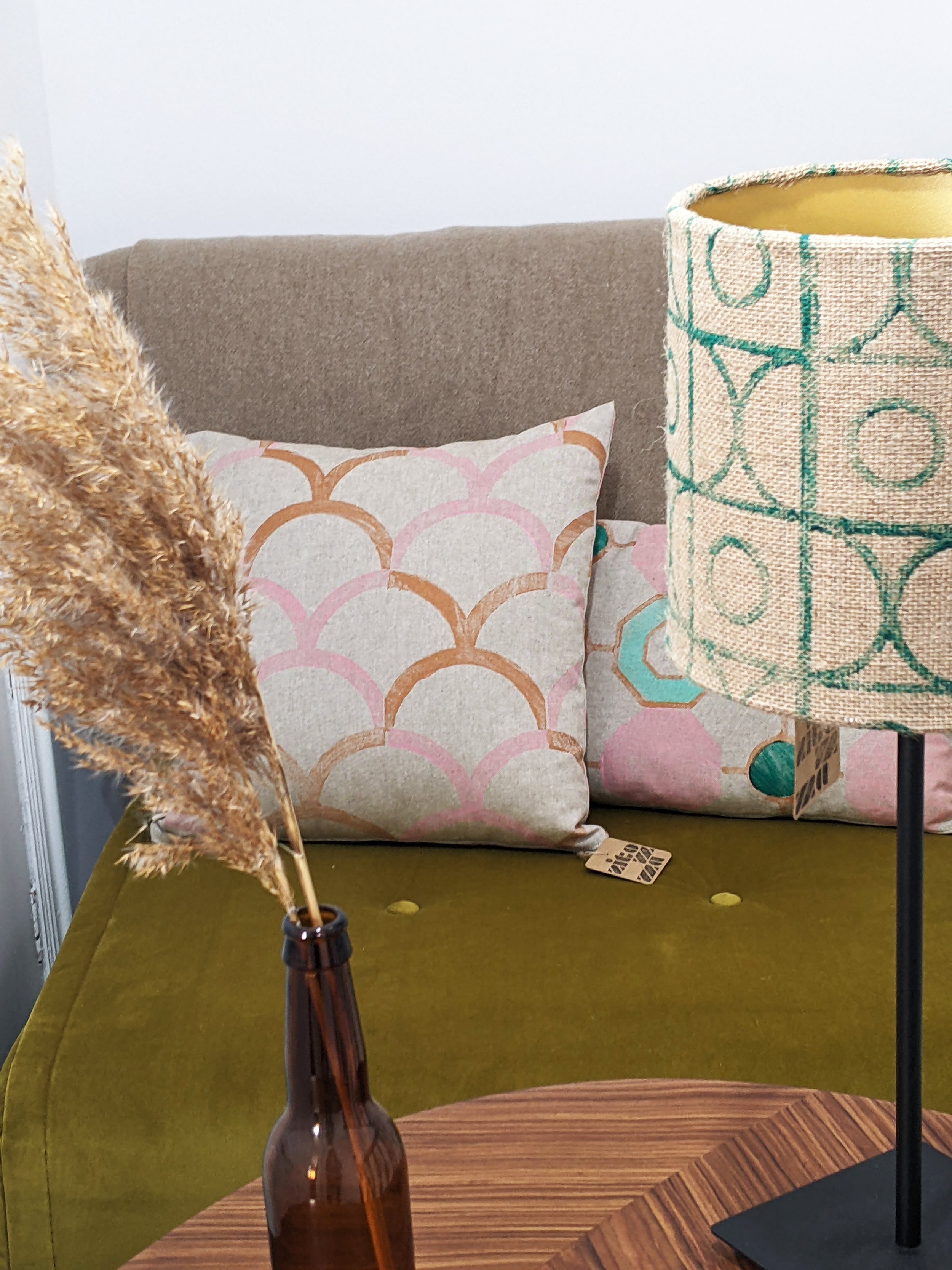 boho interior scene with hand block printed cushions and lampshade with vintage deco inspired patterns in pastel pink and green colours