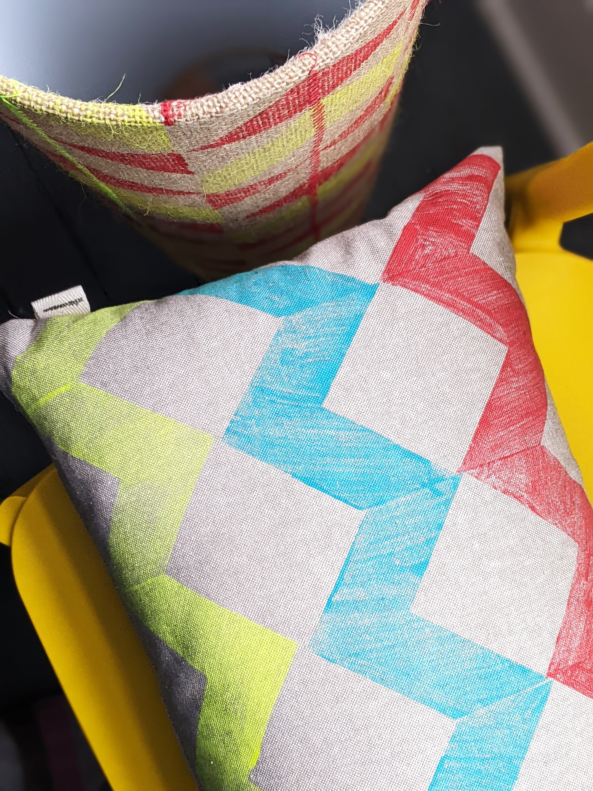 hand block printed details of colourful print on rectangular cushion on yellow chair