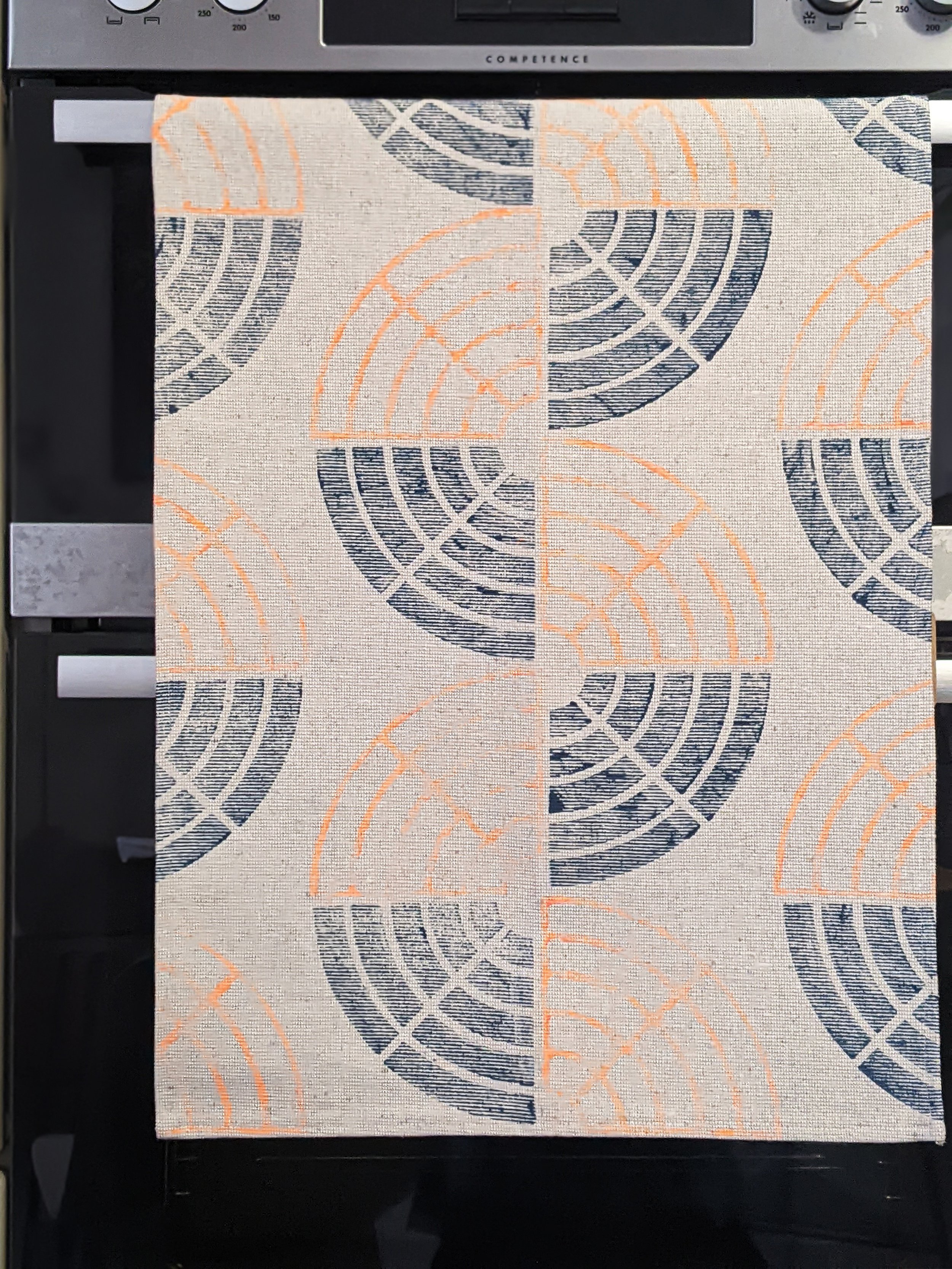 bright geometric pattern on teatowel hanging from oven