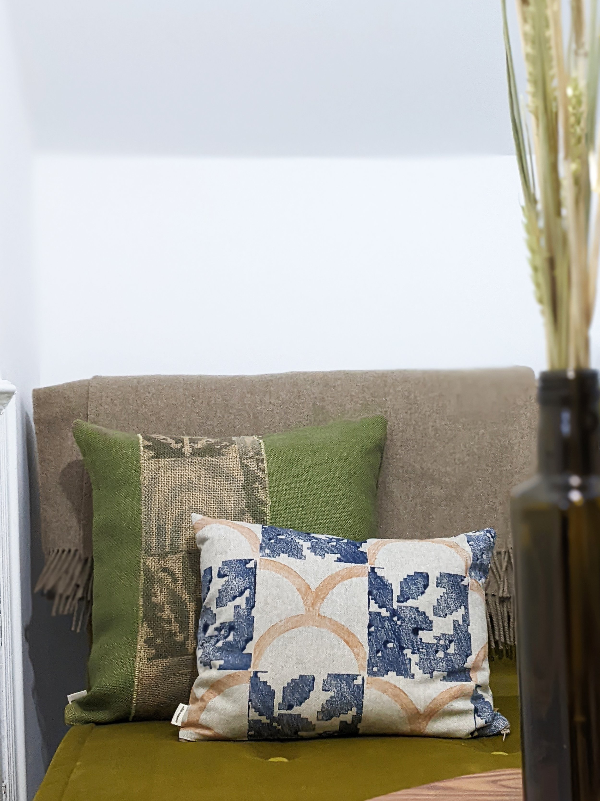 modern rustic living room interior set with block printed cushions on seat in earth tones and dried flowers