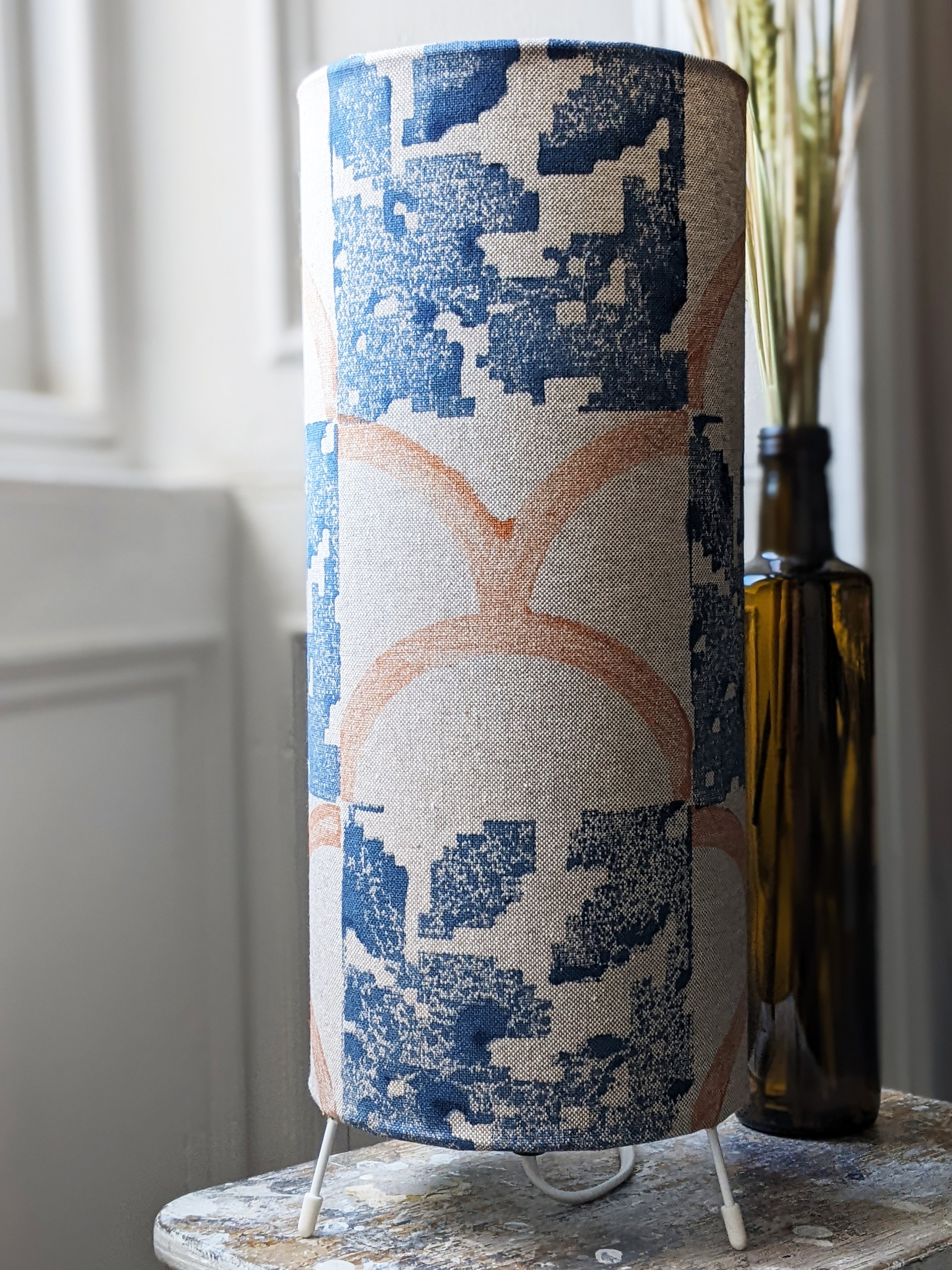 modern rustic interior scene with small floor lamp on wooden stool in heritage-inspired block print