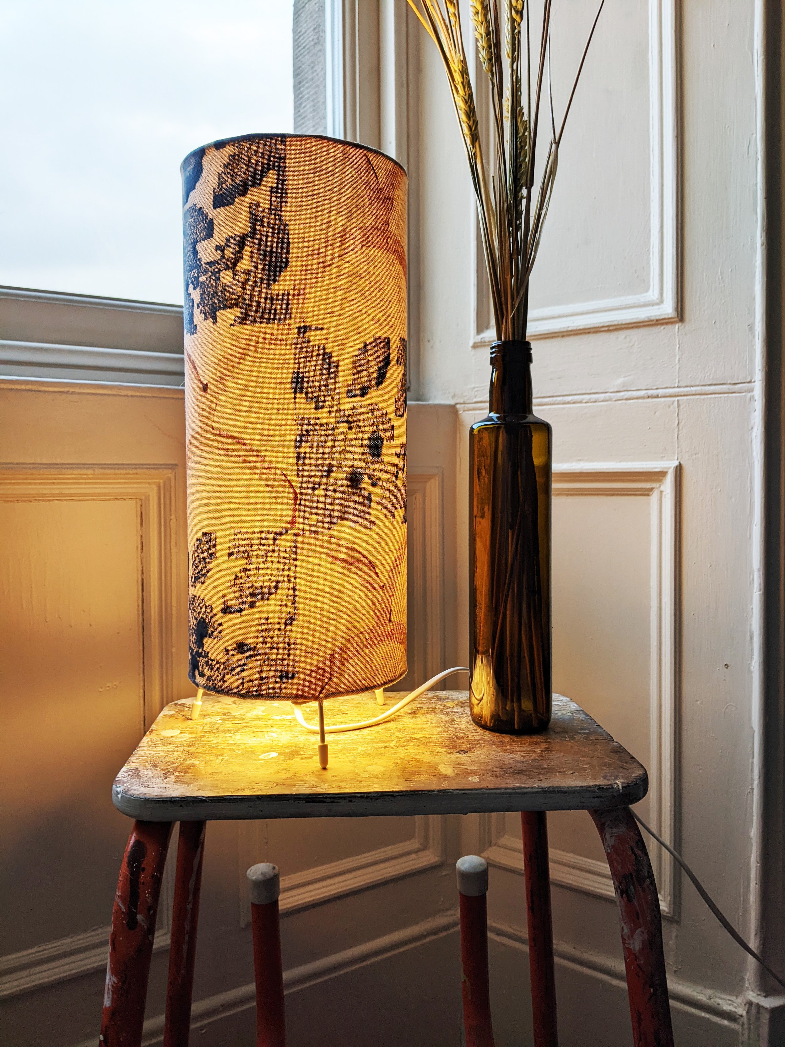 boho vintage inspired rustic interior scene with illuminated floor lamp in botanical print