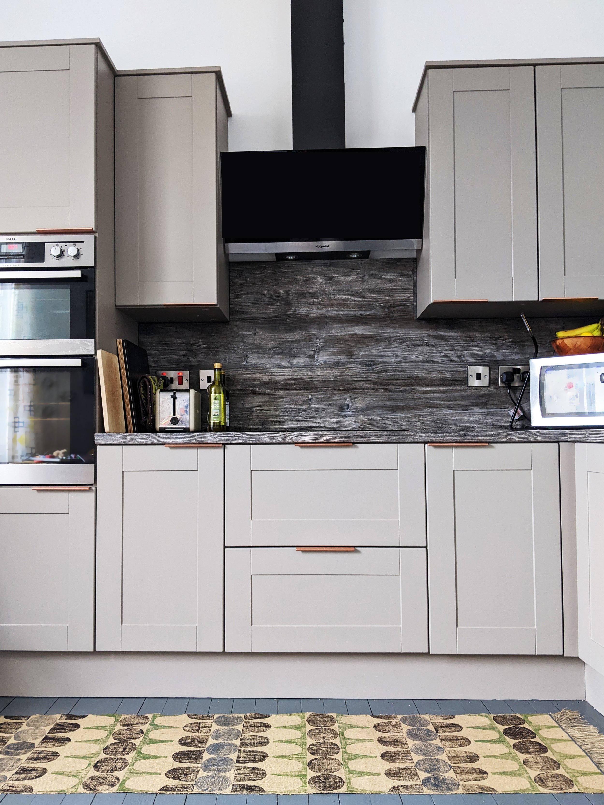 contemporary grey kitchen scene with brutalism-inspired rug on floor
