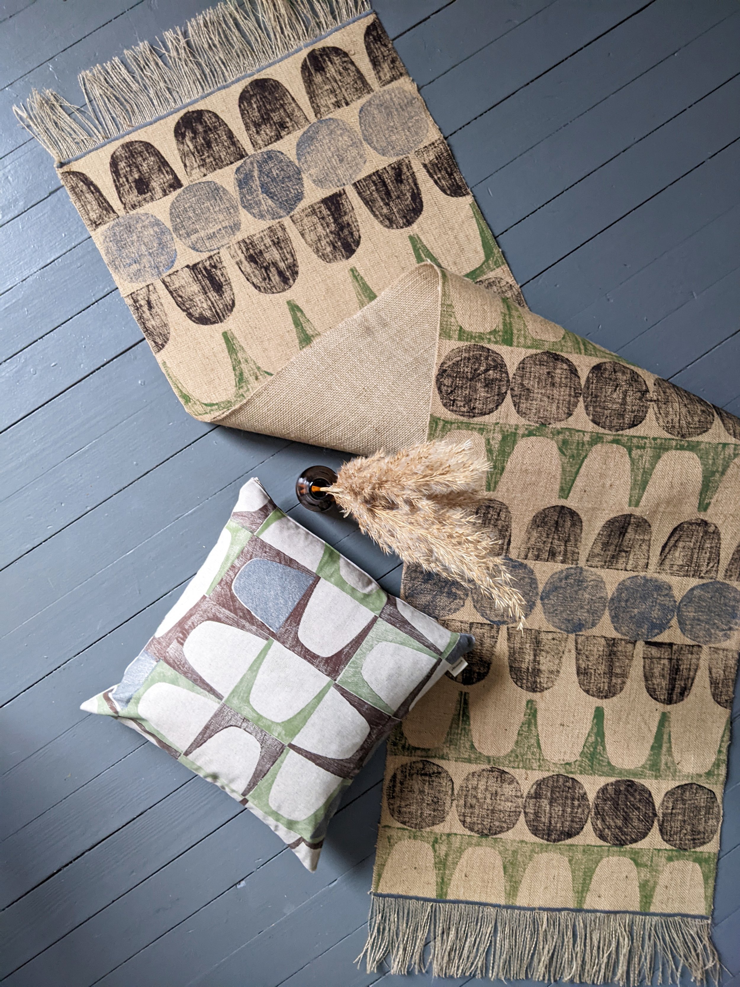 abstract geometric jute runner rug on floor with hand block printed pattern and cushion with dried flowers