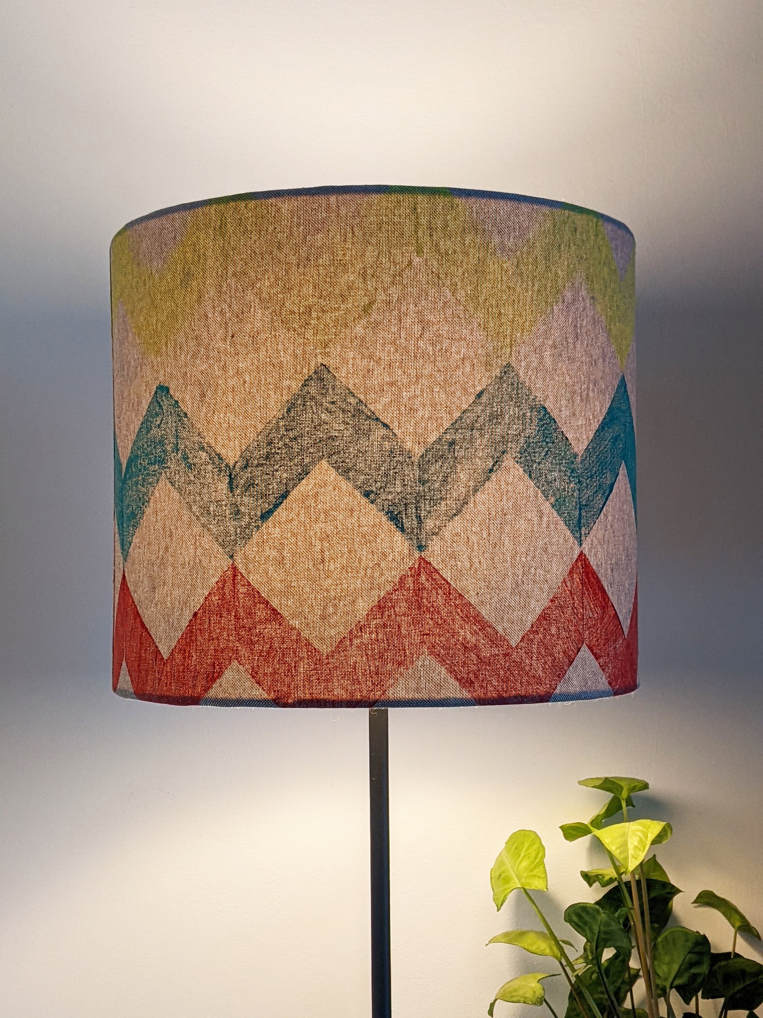 brightly lit lampshade with cosy warm light and colourful geometric pattern