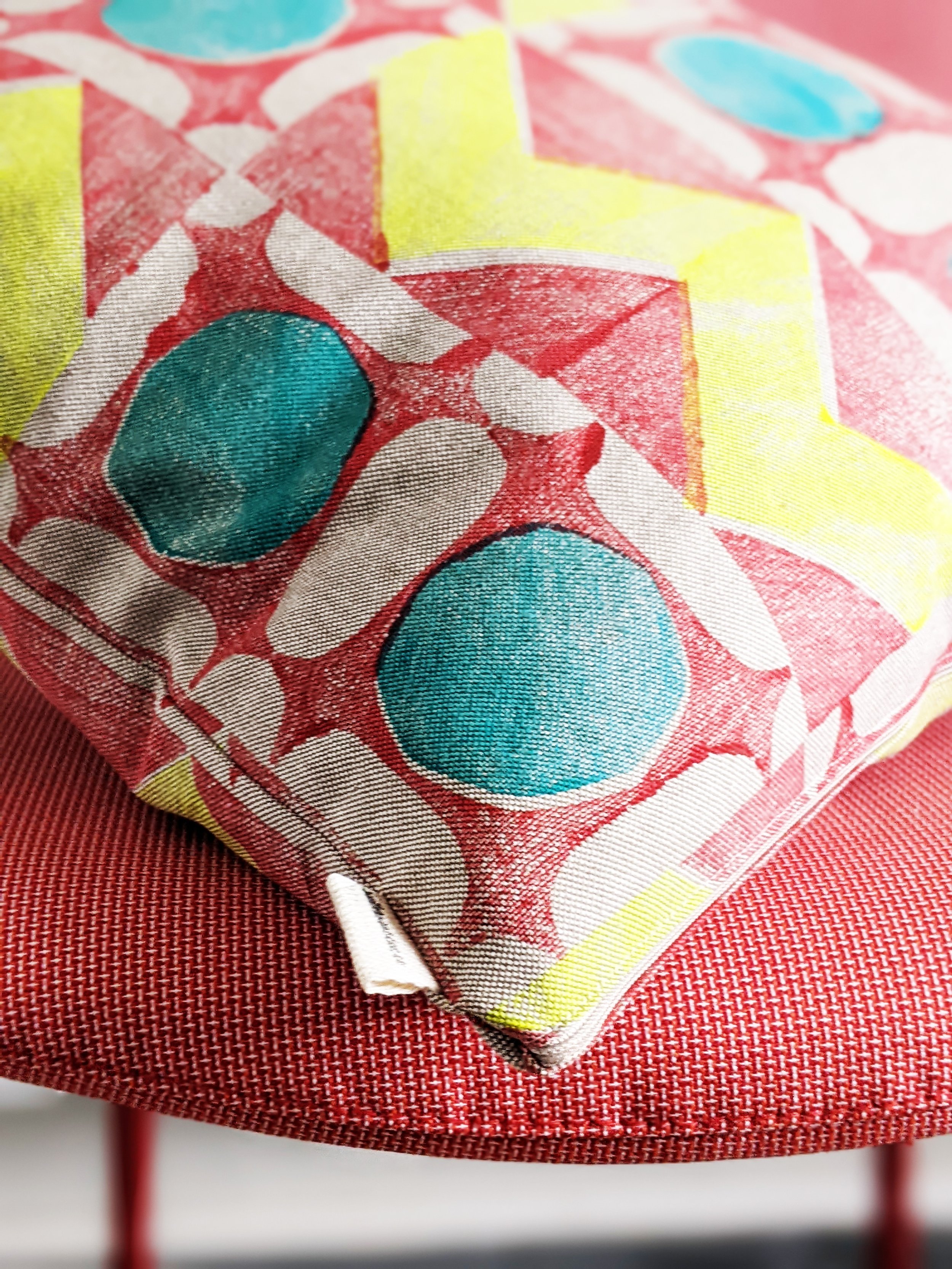 close-up detail of block printed pattern on bright geometric cushion