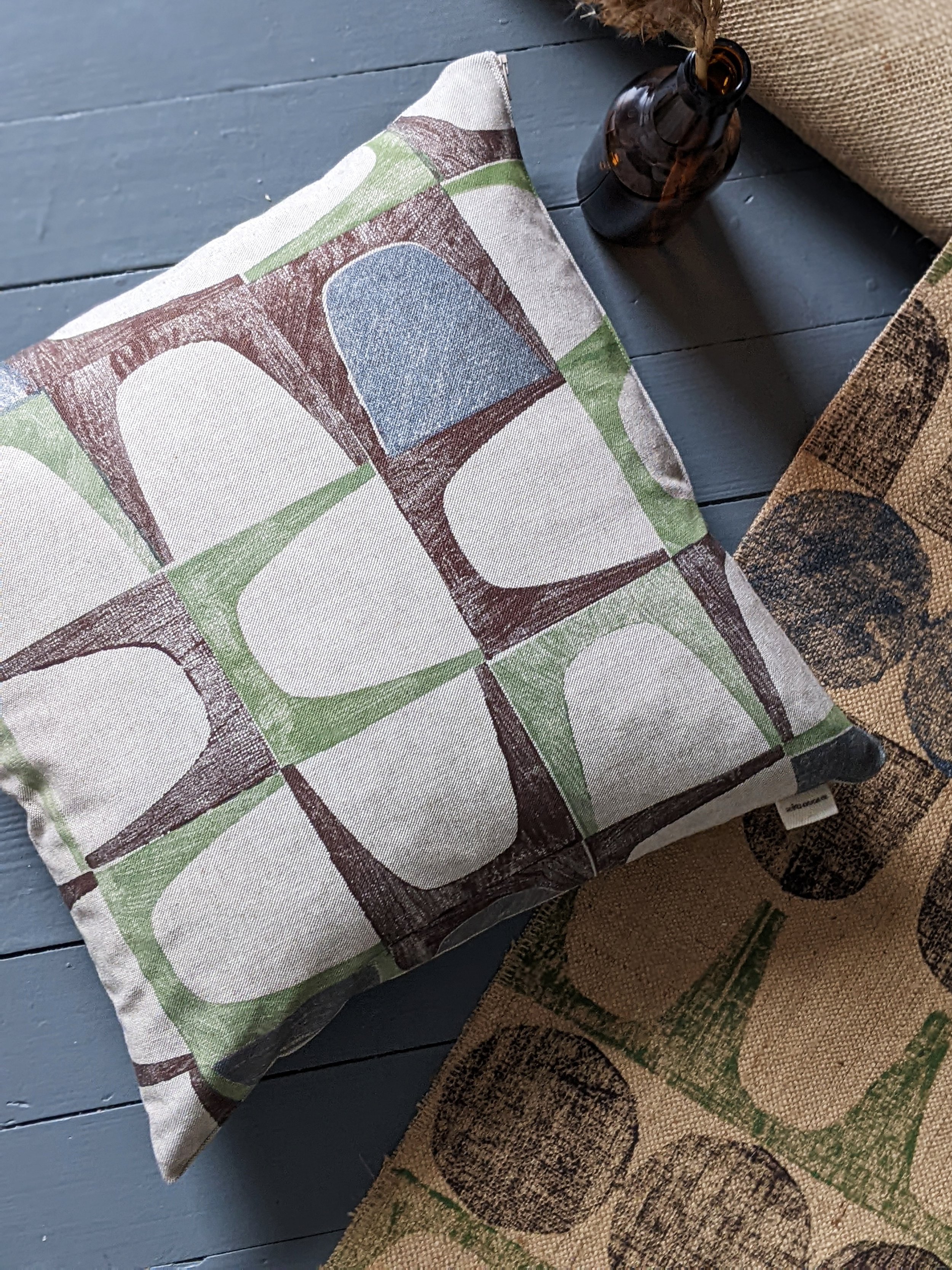 brutalism inspired abstract geometric pattern on contemporary cushion on mid-century-modern inspired rug on floor