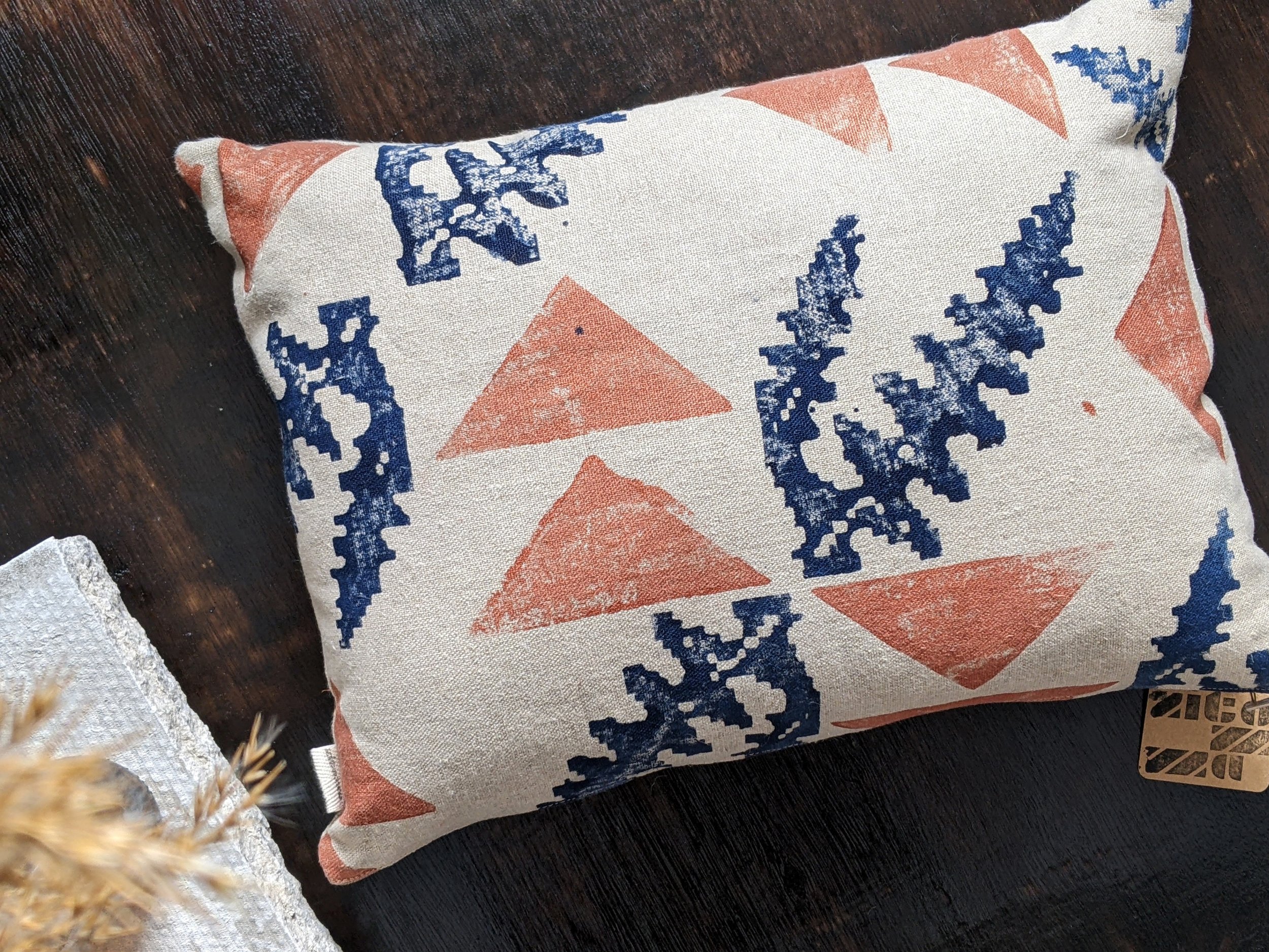 small rectangular cushion with botanical and geometric hand printed pattern in copper and navy blue