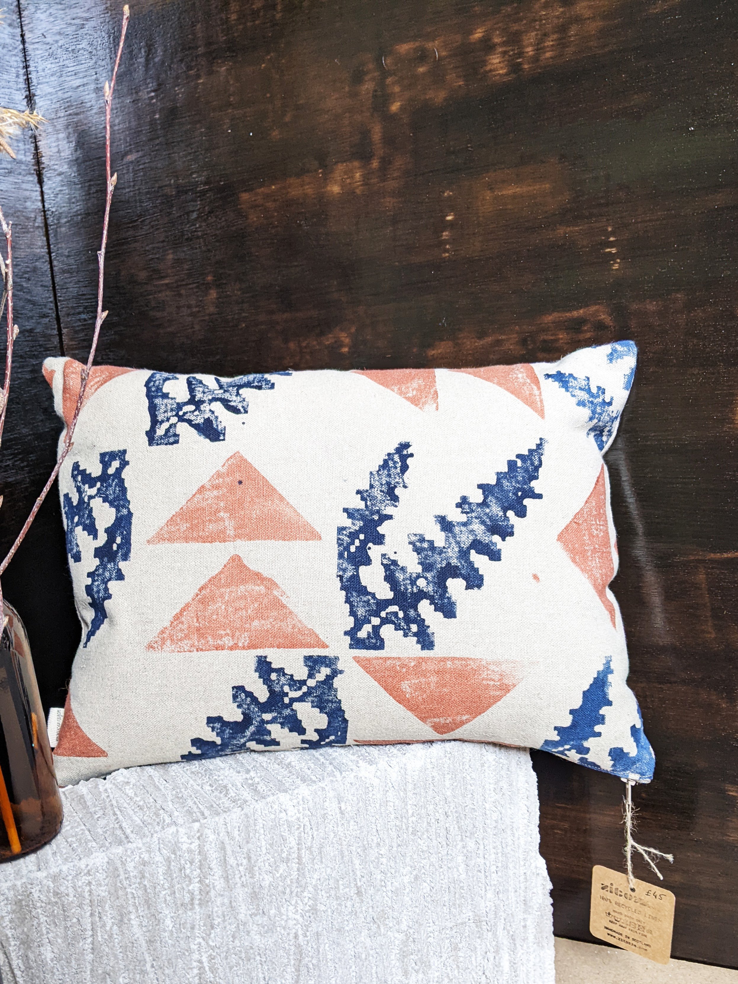 small rectangular linen cushion on a grey brick