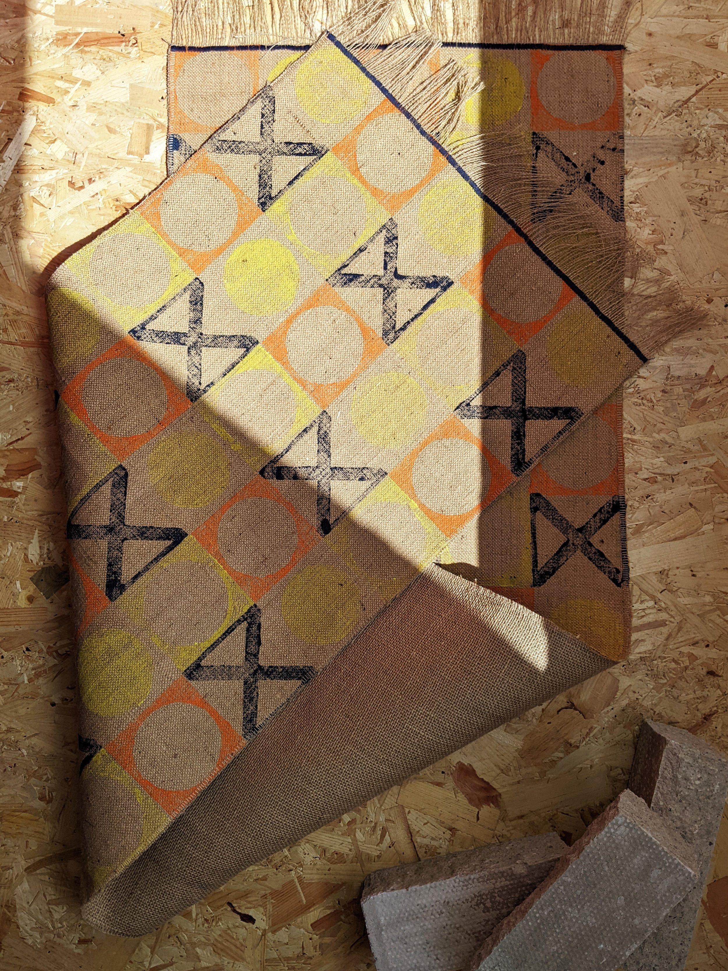 folded jute runner rug with architectural patterns in studio scene with construction materials