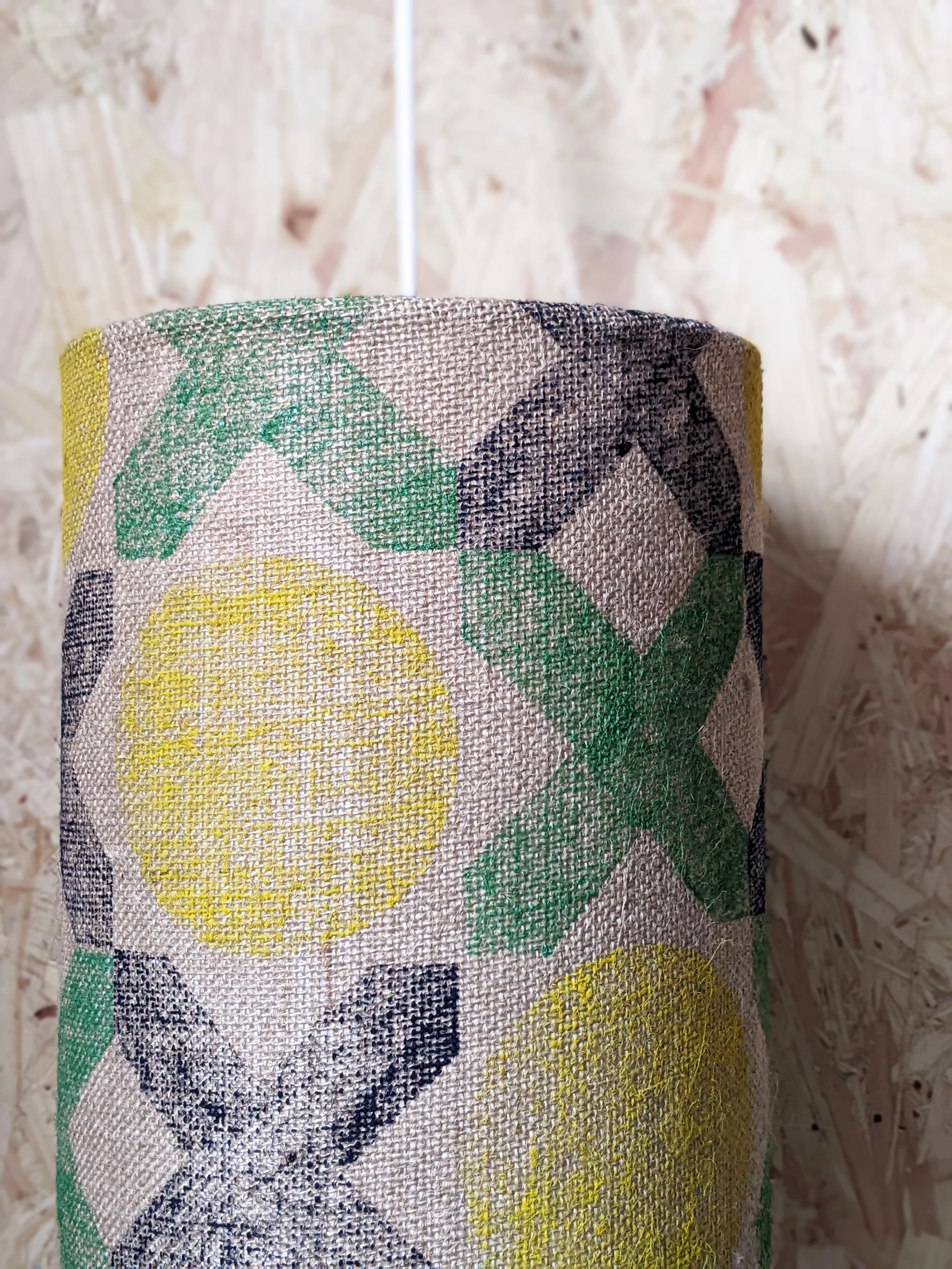 close-up details of hand block printed geometric pattern on jute in navy, green and yellow