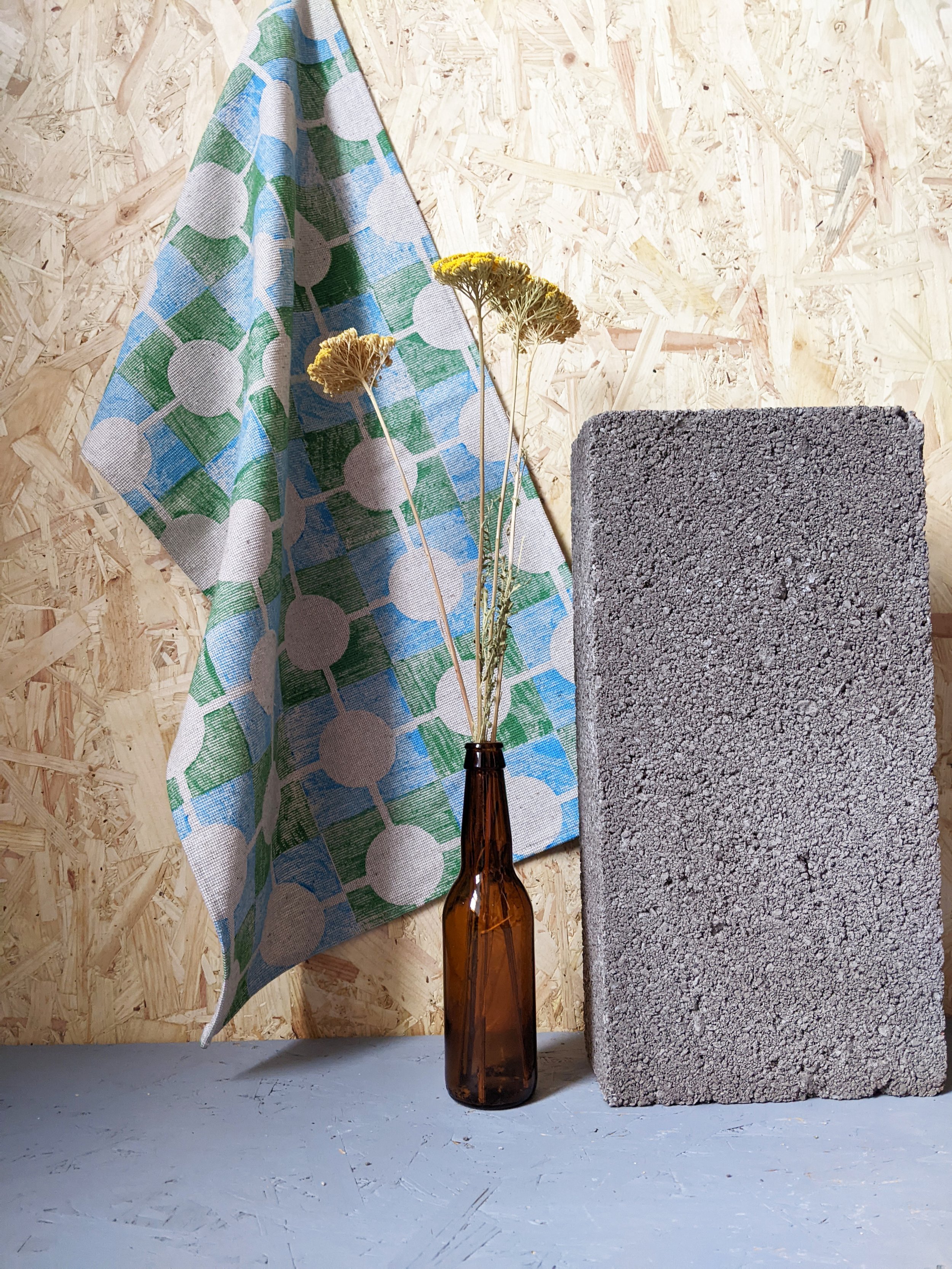 contemporary studio scene with bold green and blue printed teatowel hanging on wall