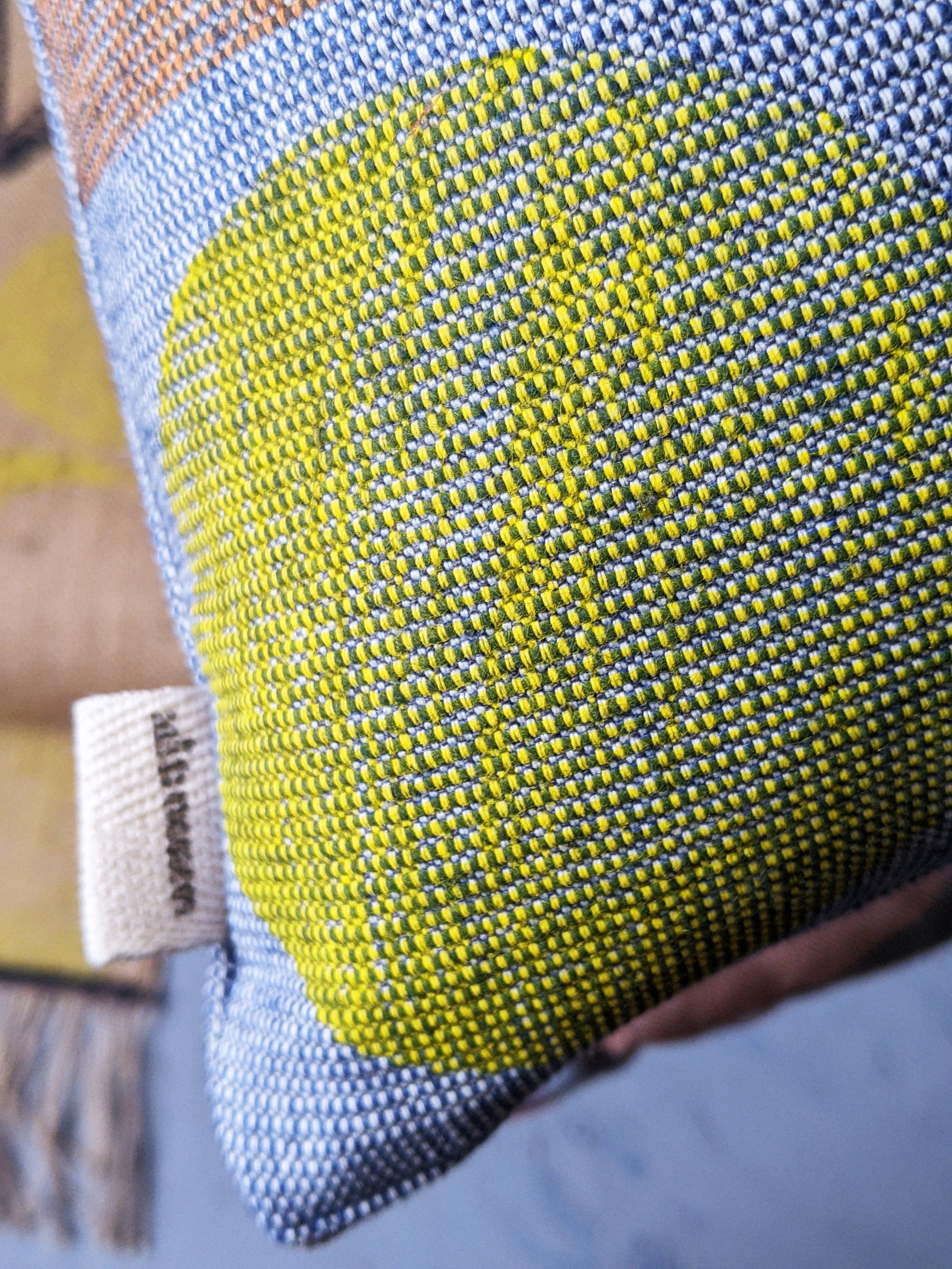 close-up detail of textured blue fabric with yellow circle print