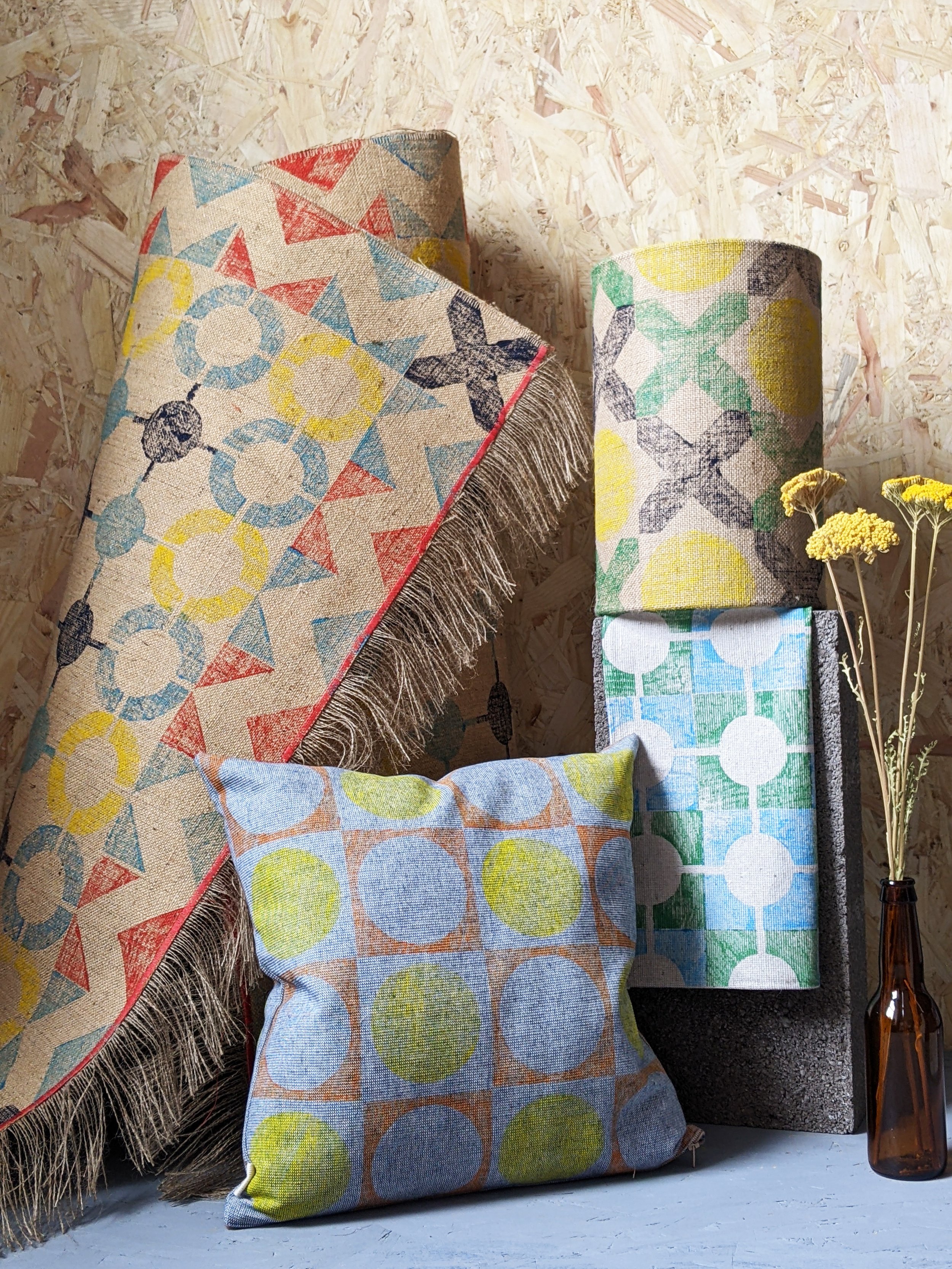 bright studio scene with vibrant home accessories, colourfully hand block printed in architecture-inspired geometric patterns