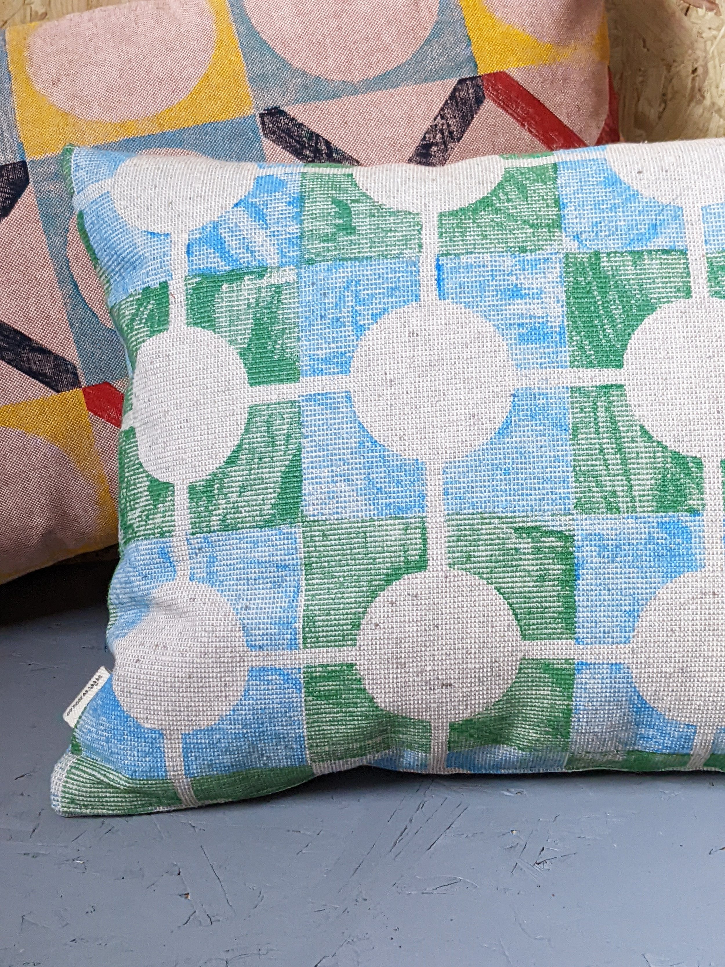 close-up detail of ribbed texture and block printed pattern on colourful geometric cushion