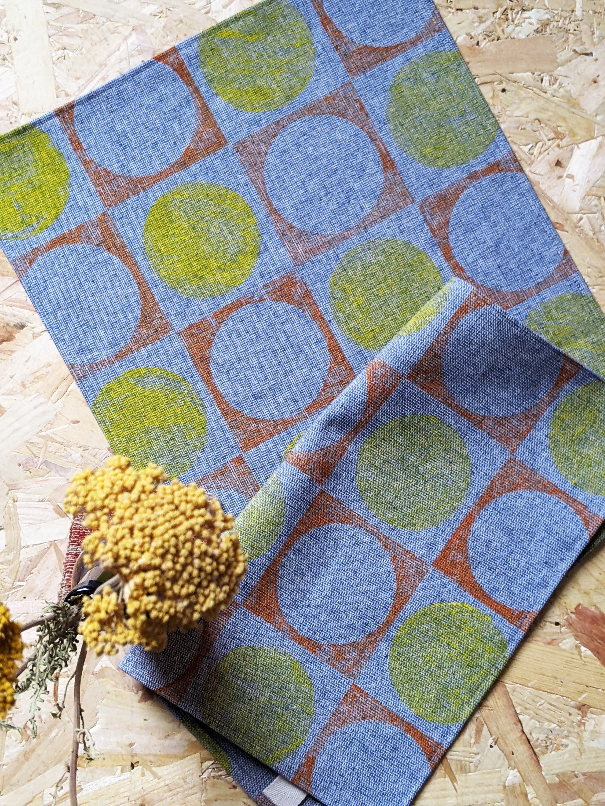 1960s modernism inspired circular geometric pattern in yellow and orange on denim-like fabric for kitchen decor