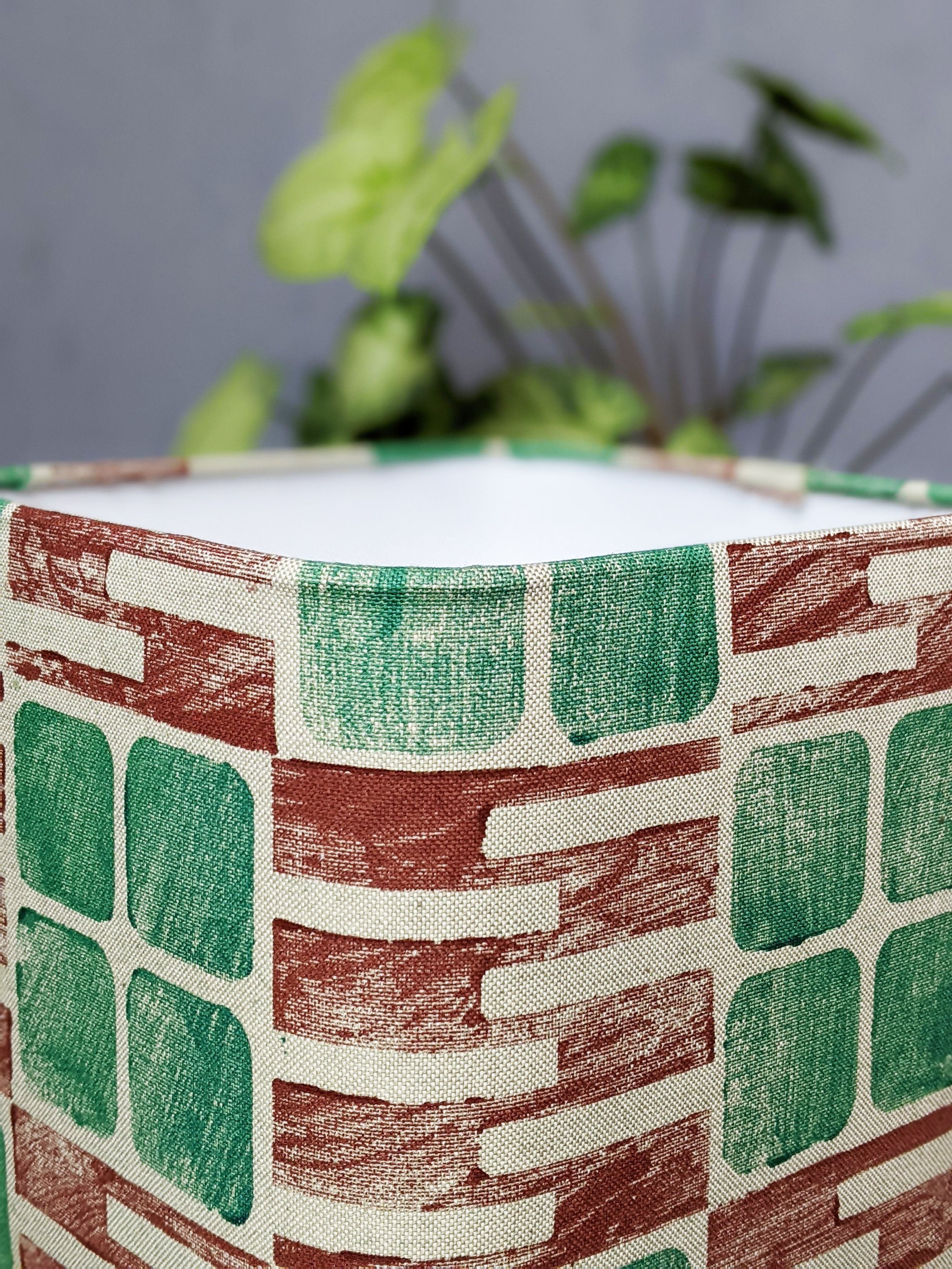 close-up detail of block printed pattern on sage textile on square lampshade with architecturally inspired print