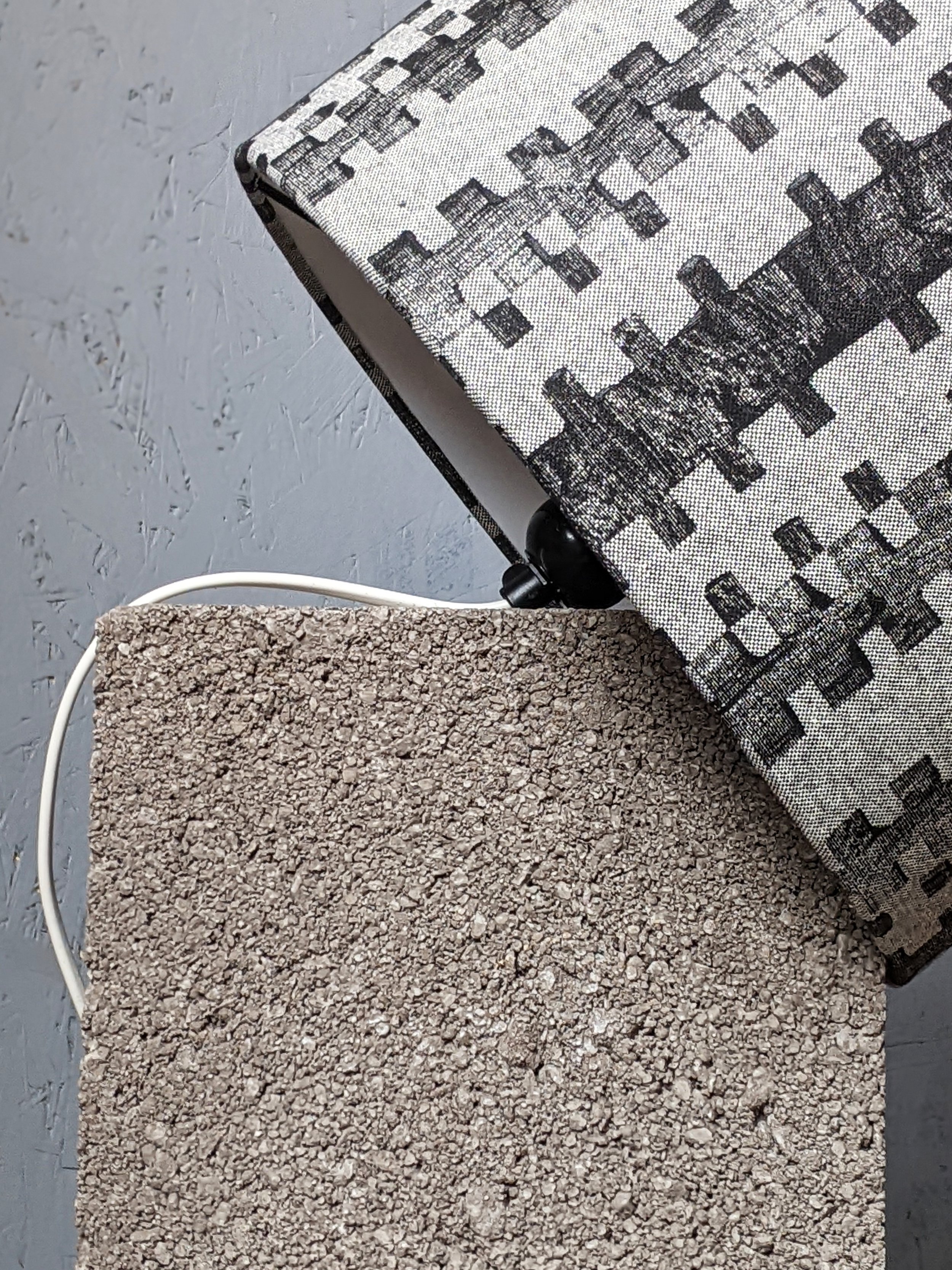 architectural inspired black and grey lampshade on concrete block