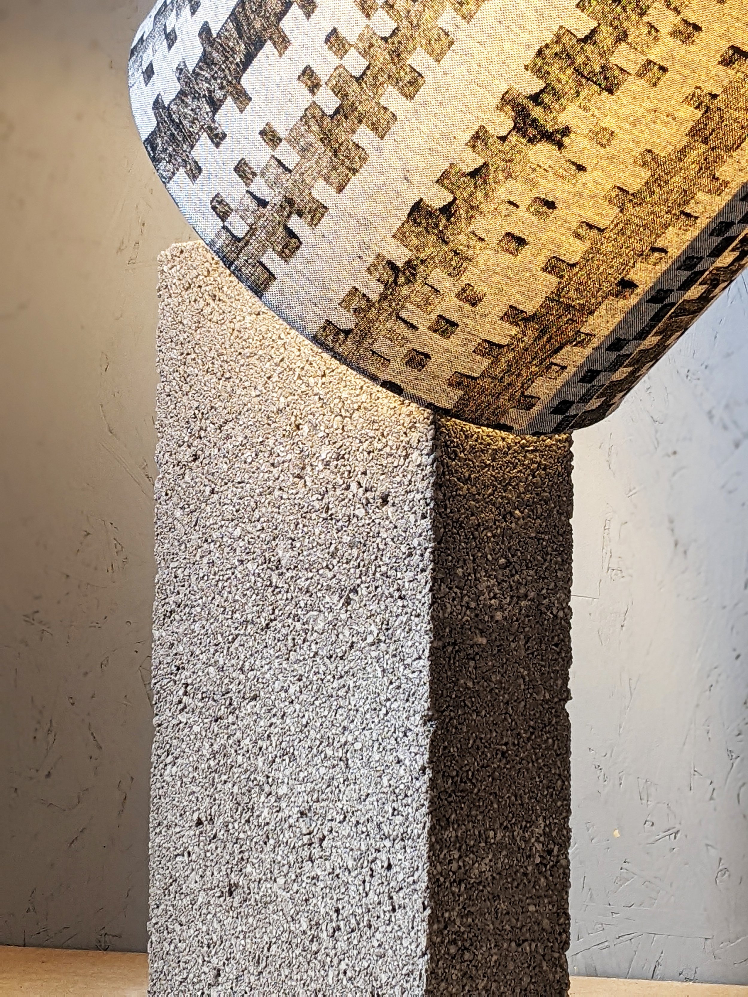 architectural lampshade in black block printed brutalist pattern standing on concrete block