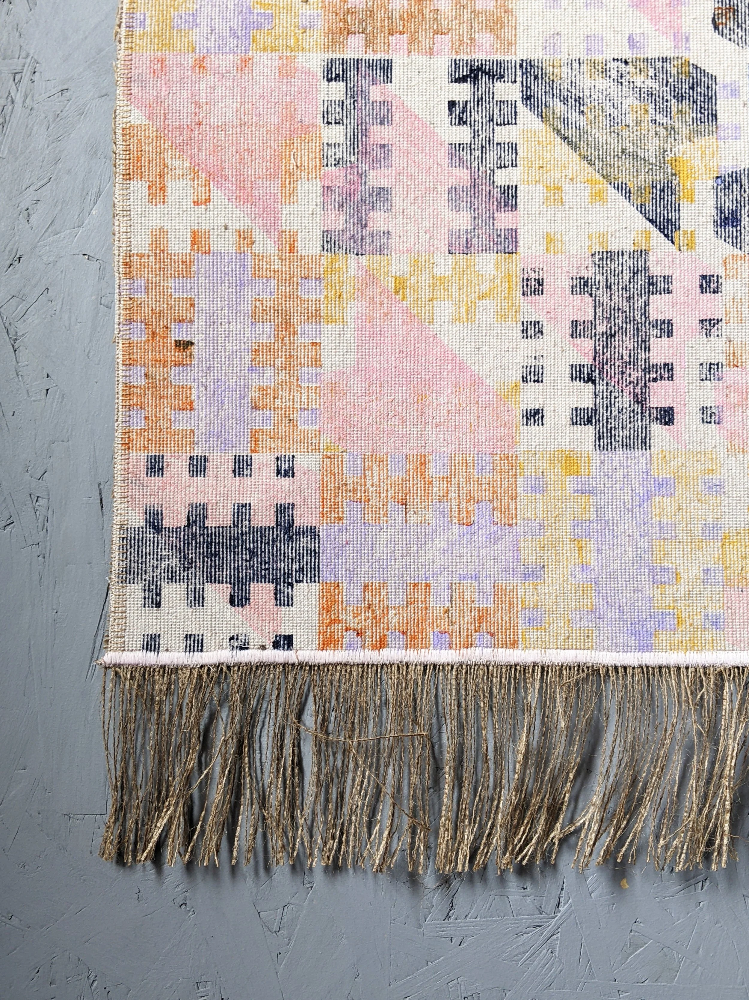 close-up details of pastel colours on block printed, abstract geometric textile wall art