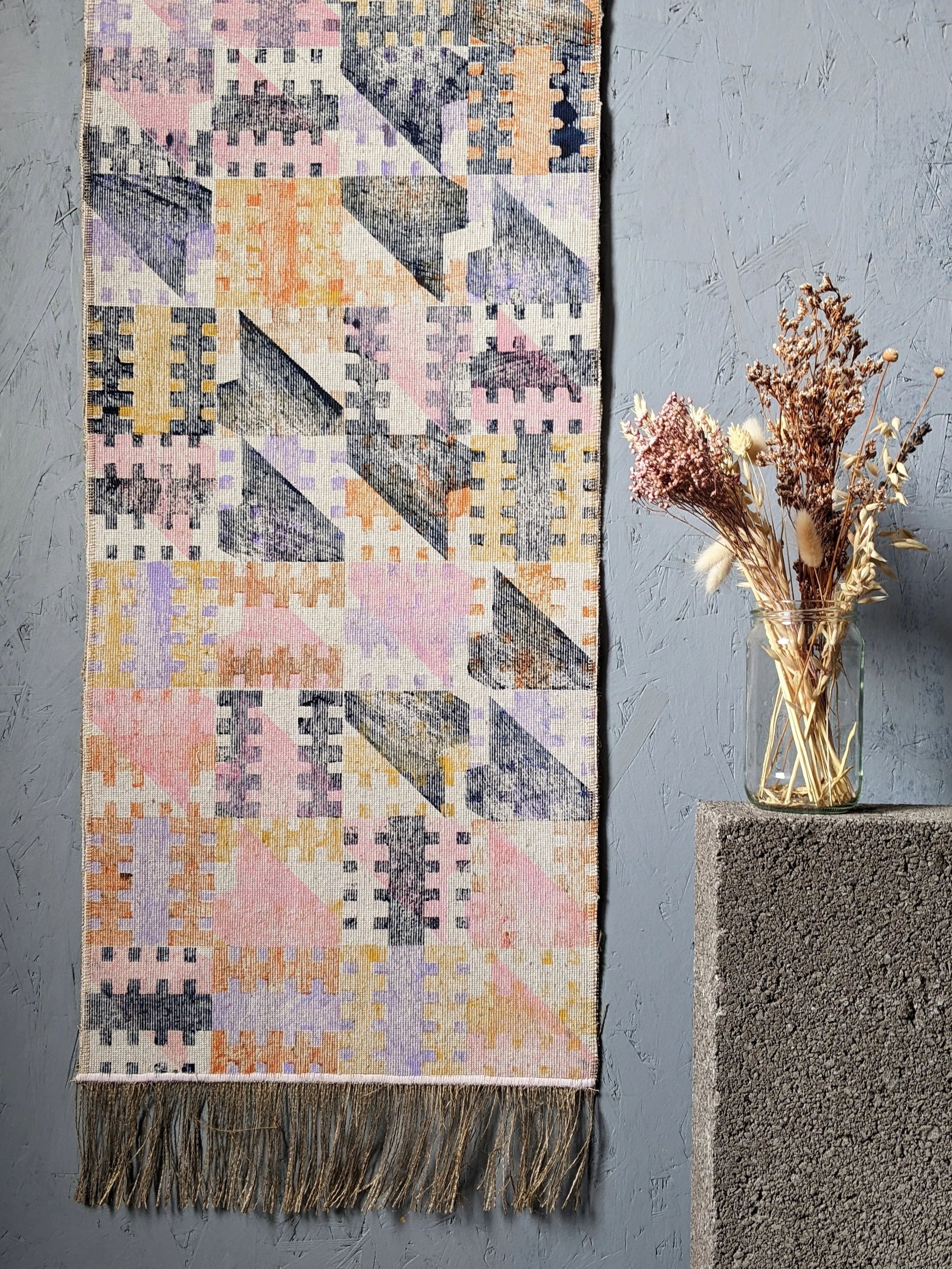 architecturally inspired block printed wall hanging with pastel colours and navy on wall