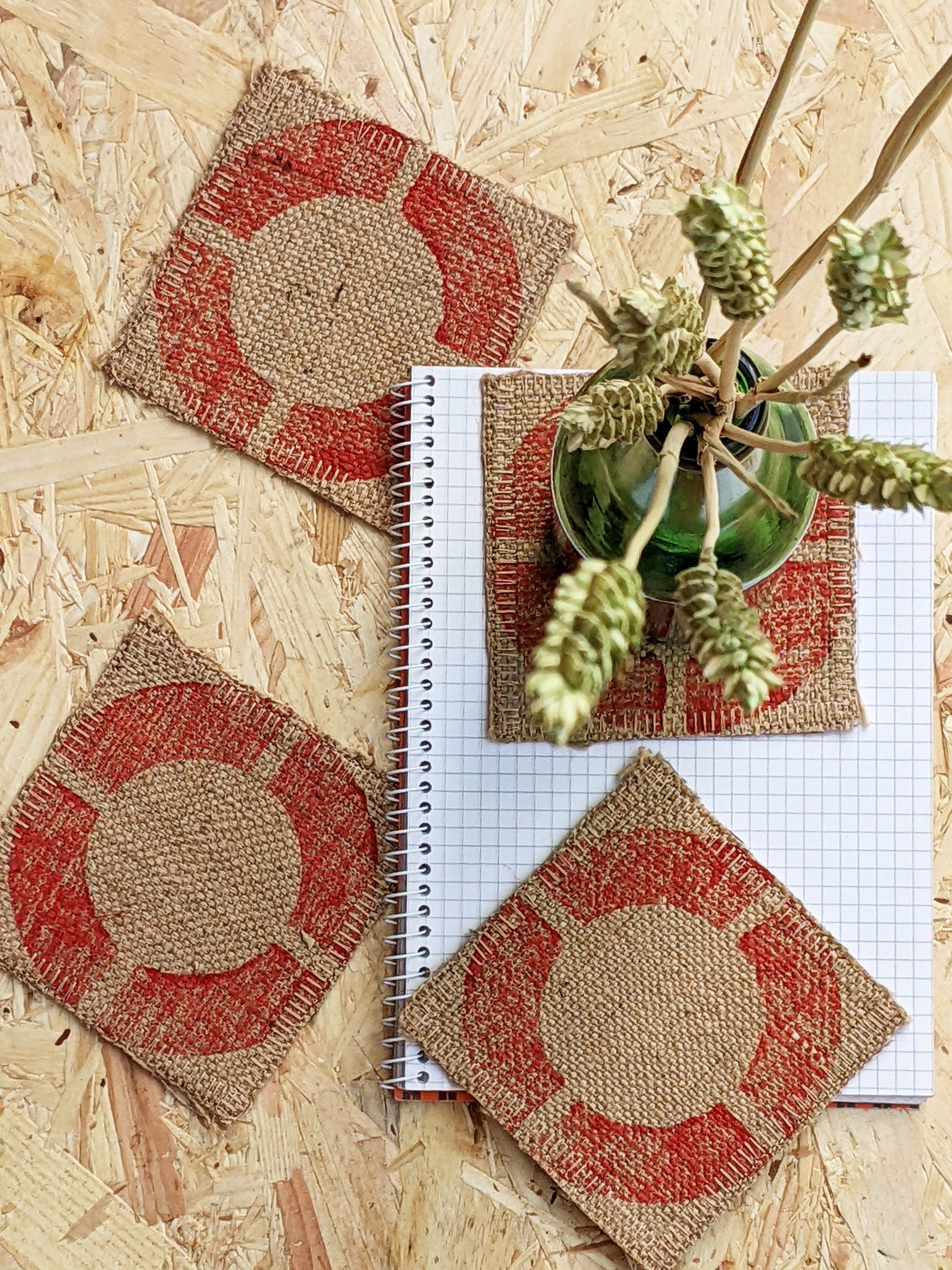 red circular geometric motif on rustic jute fabric coasters