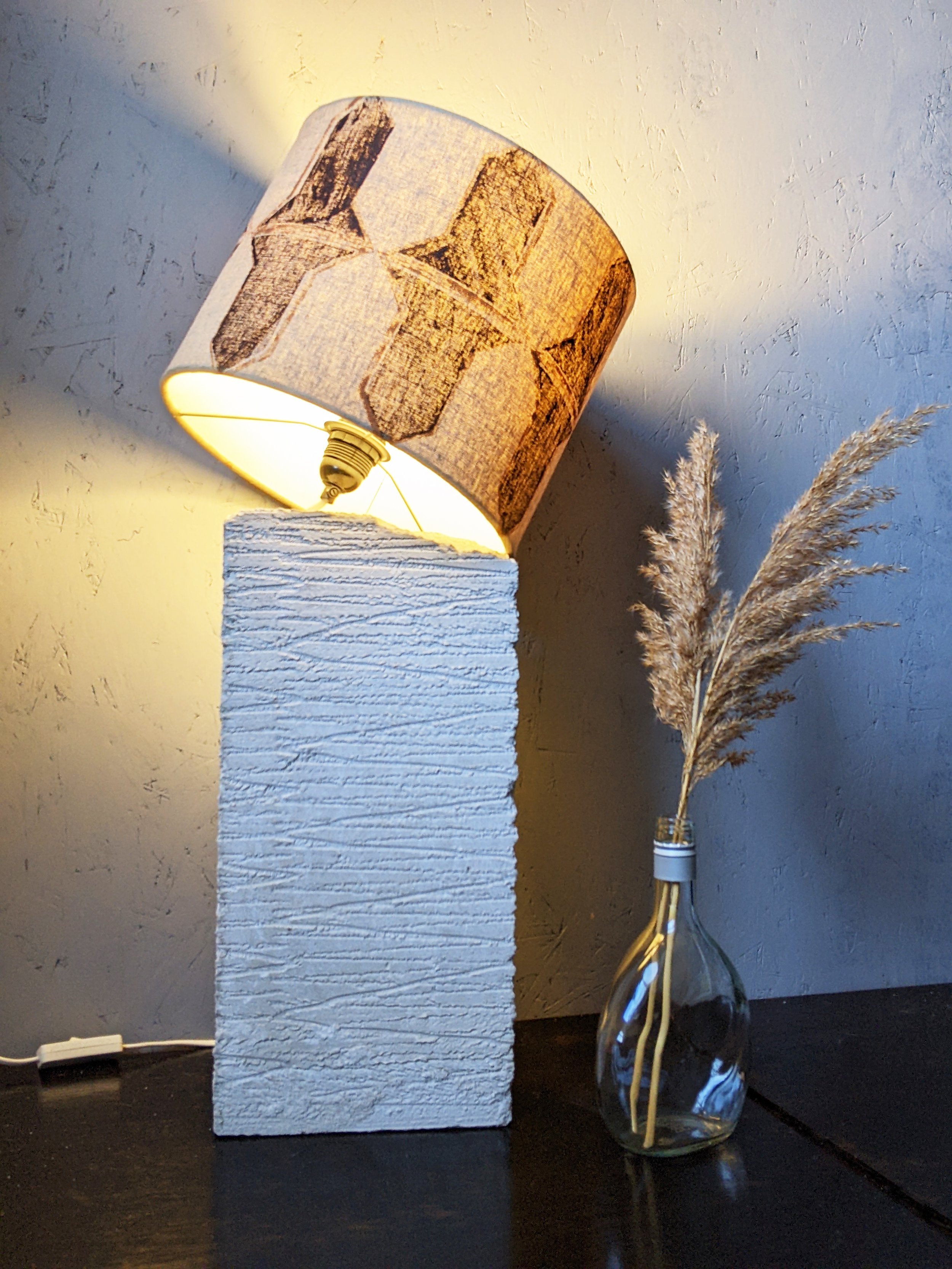 illuminated drum lampshade in abstract geometric print on breeze block