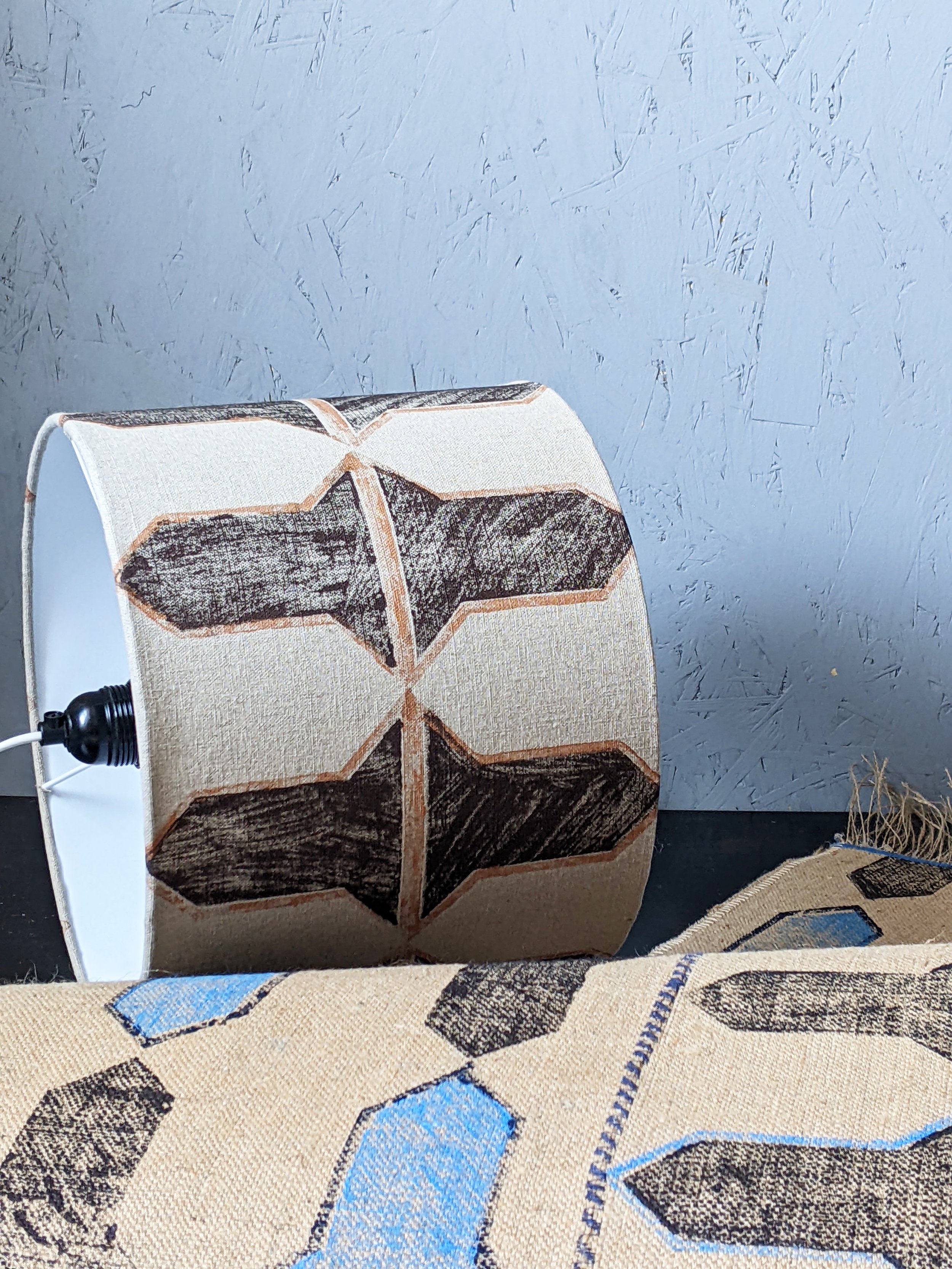 hand block printed drum lampshade on studio floor with abstract printed rug