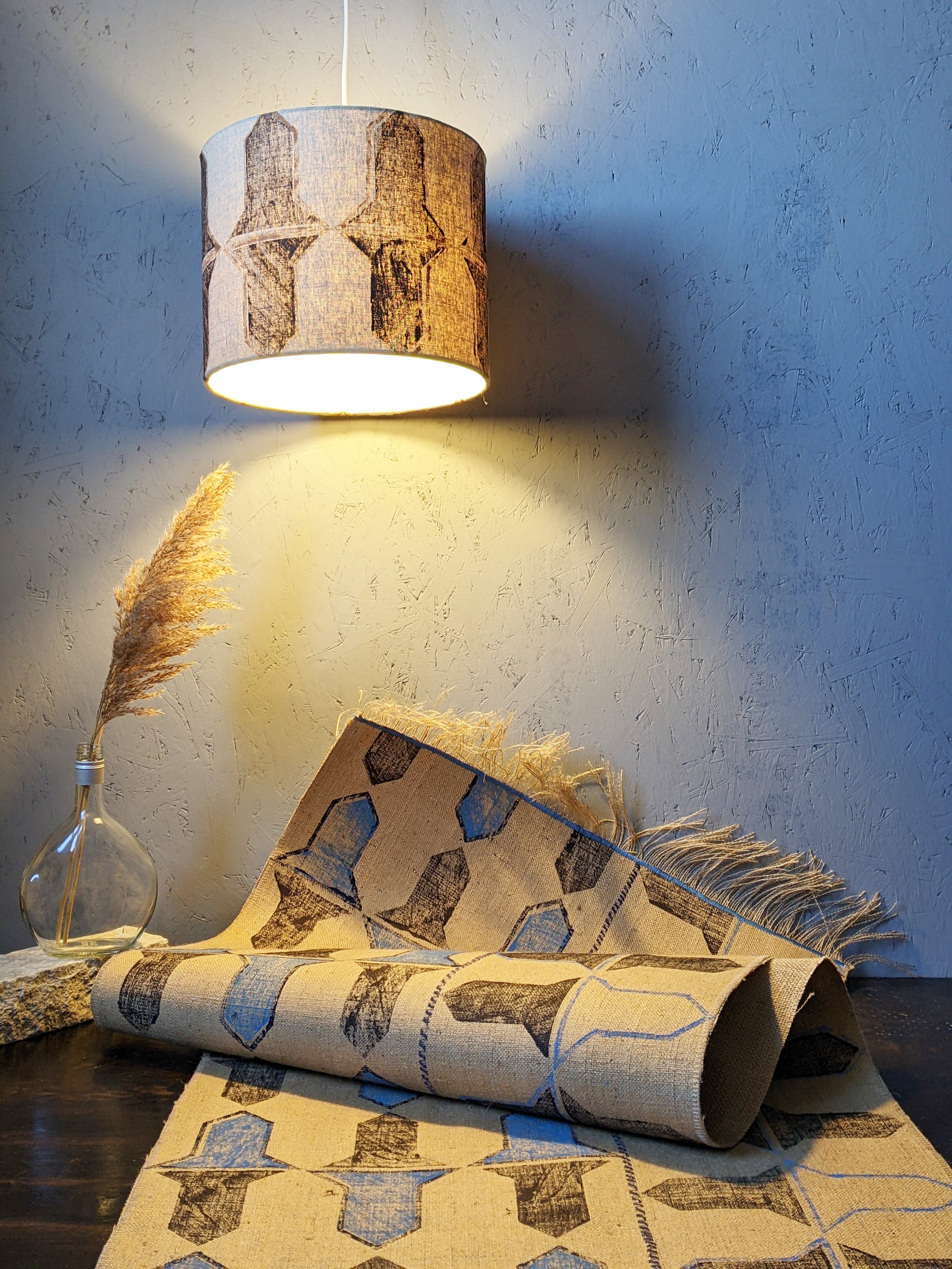 studio scene with block printed lampshade and rug in similar abstract geometric pattern in brown colours