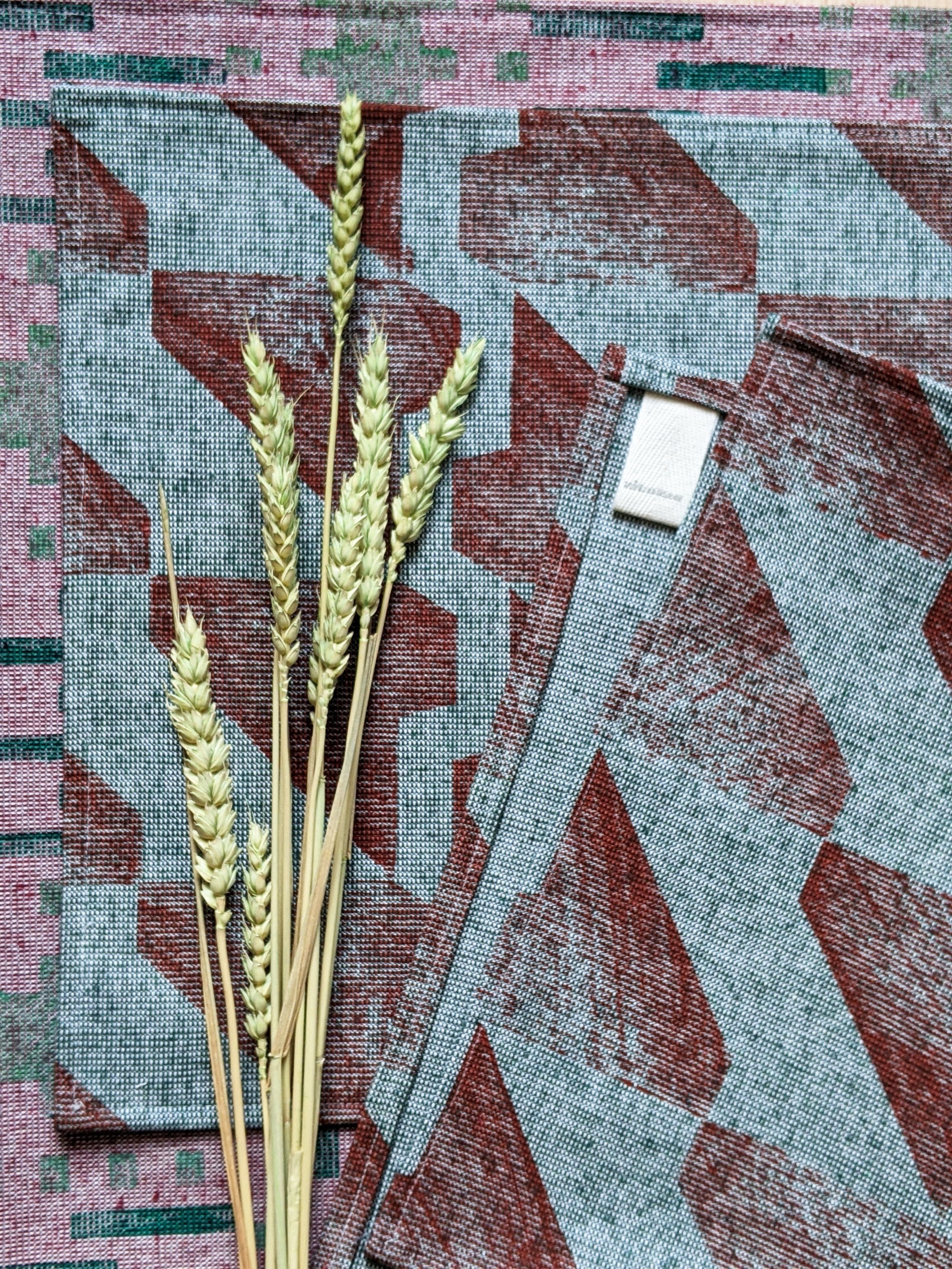 close-up details of rustic terracotta geometric print on green teatowel