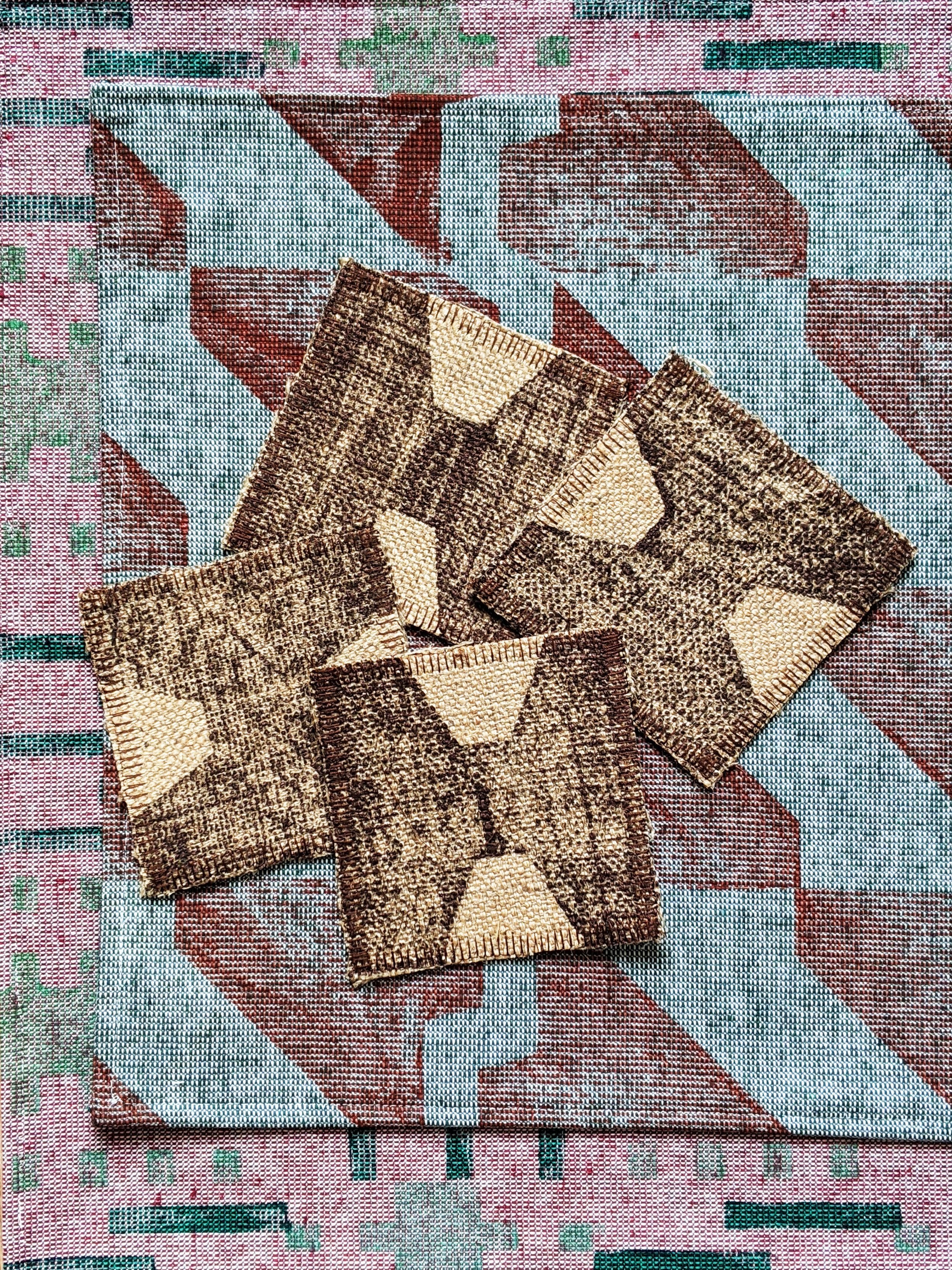 set of four brown coasters in warm brown on tactile natural jute