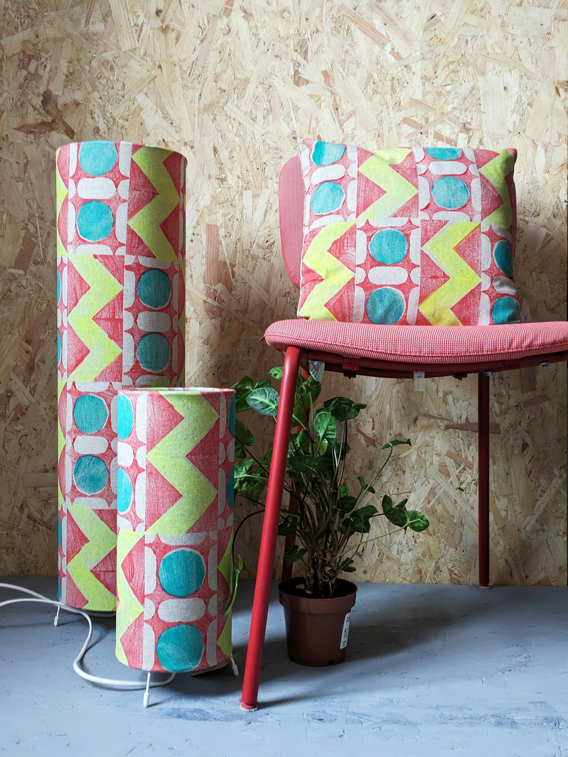 boho vibrant interior decor scene with floor lamps and cushion with same vibrant geometric pattern