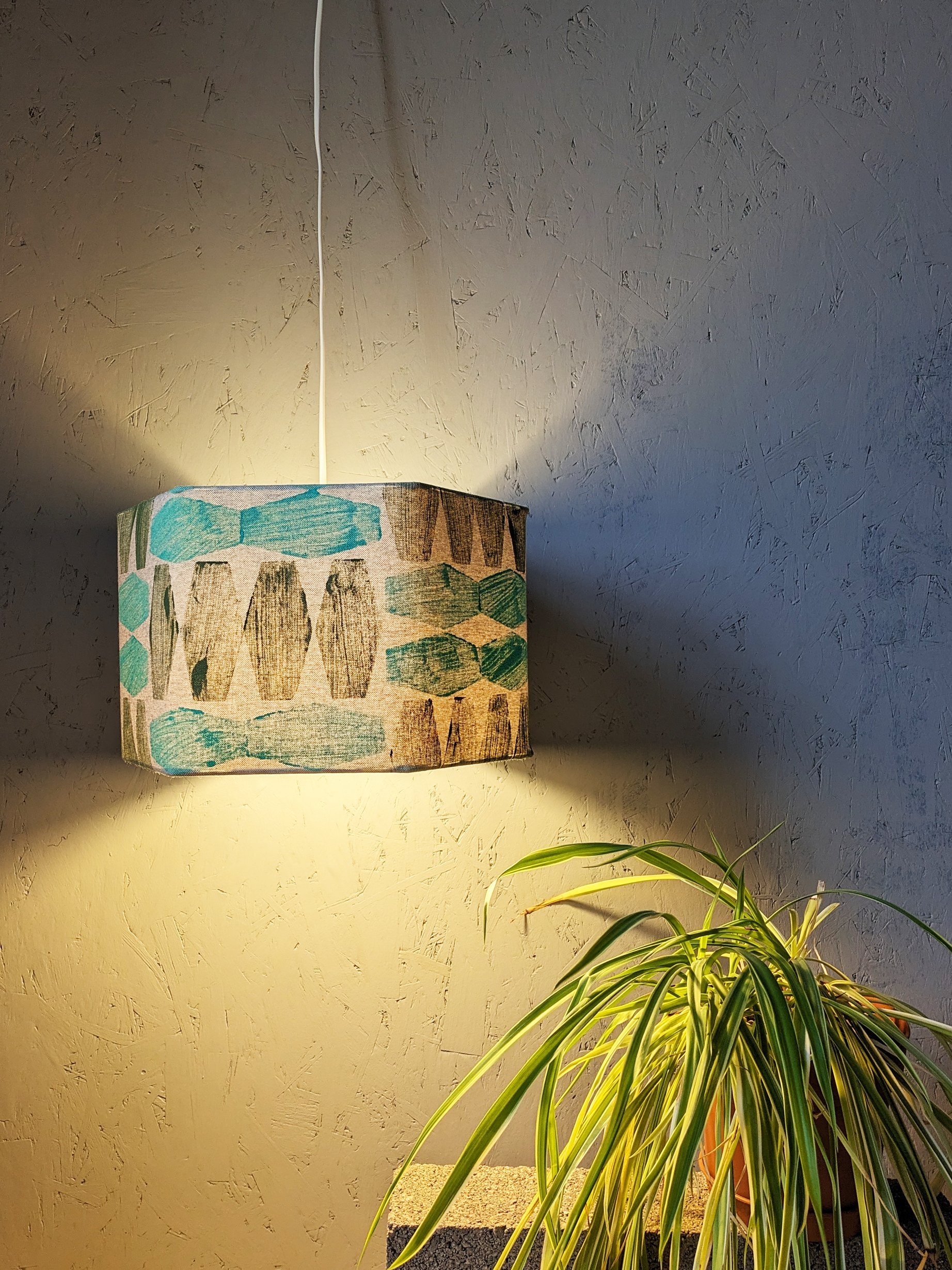 illuminated hexagonal lampshade with abstract modern print in contemporary studio