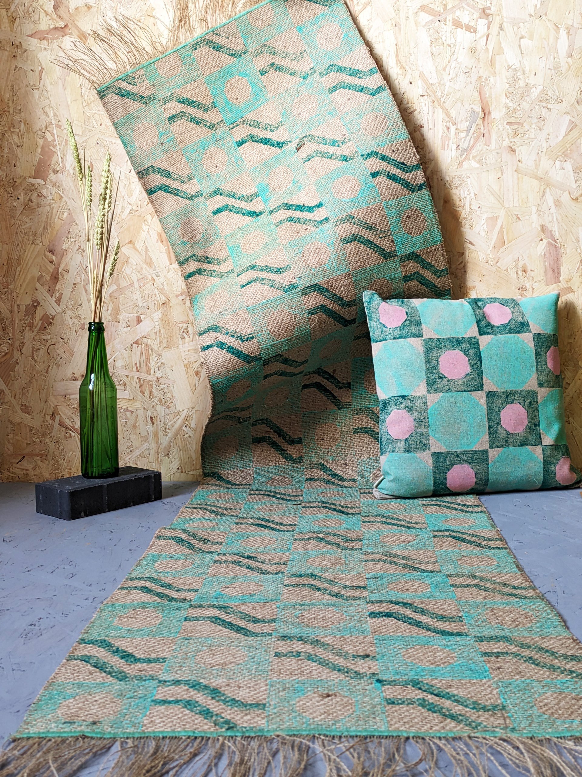 studio scene with architectural patterns on runner rug and cushion in pastel and lush green colours