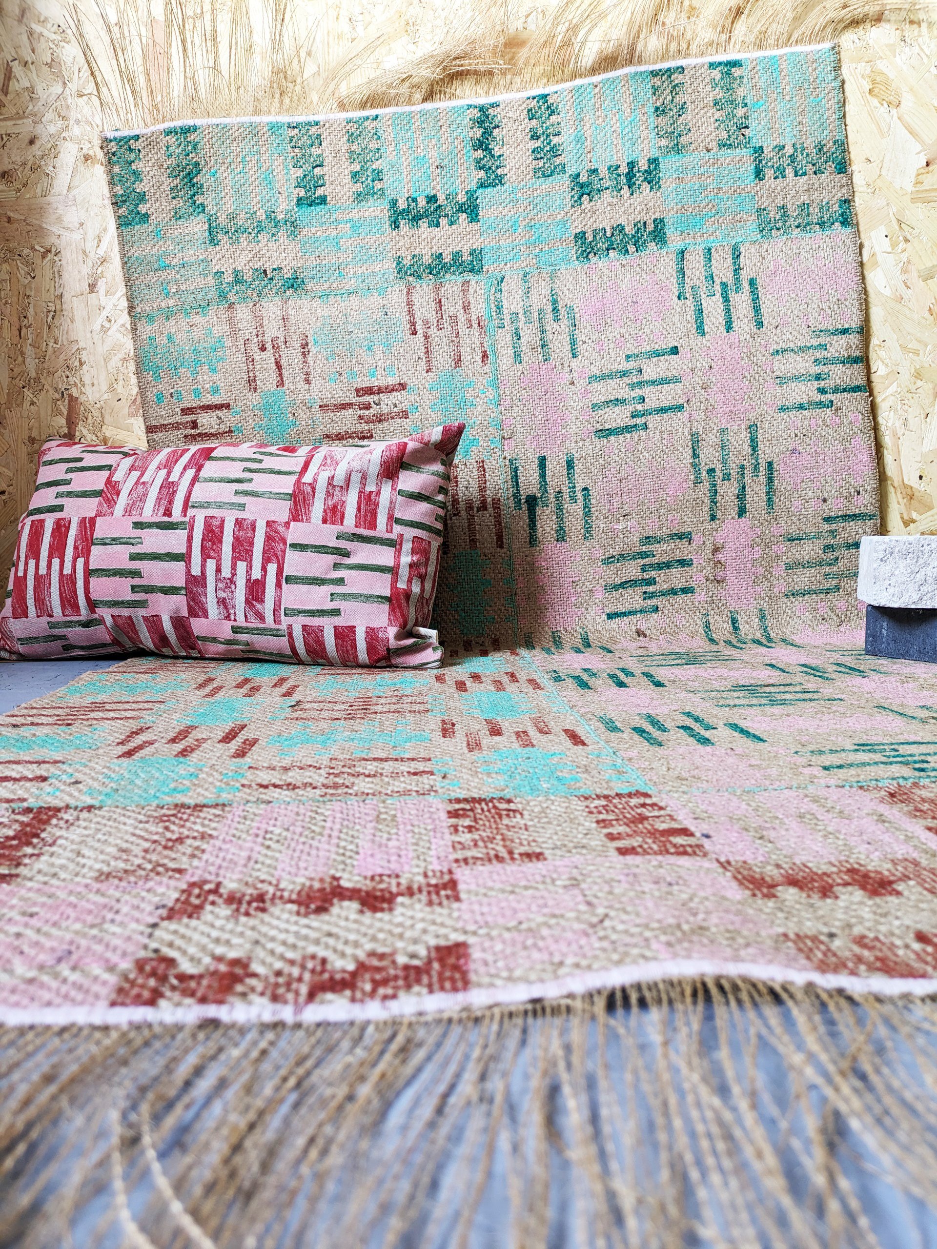 studio scene with abstract geometric architectural print on cushion and rug in pastel colours