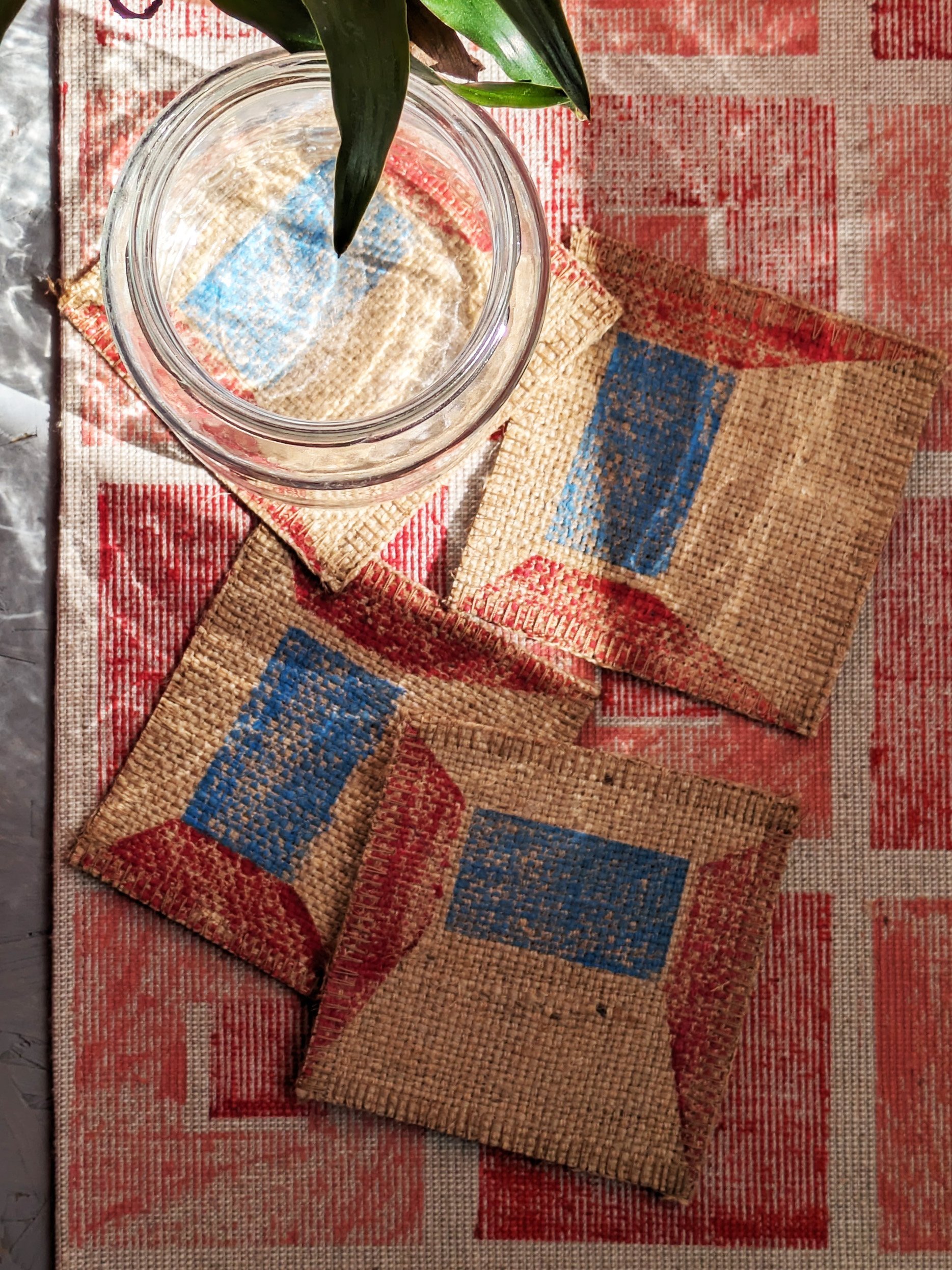 sunny kitchen table scene with block printed red and blue coasters and pink and red teatowel