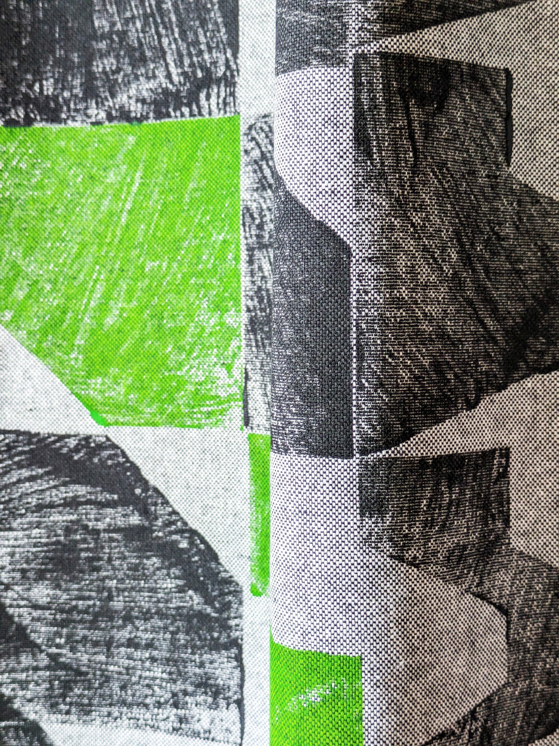 close-up detail of black and neon green print on abstract architectural pattern